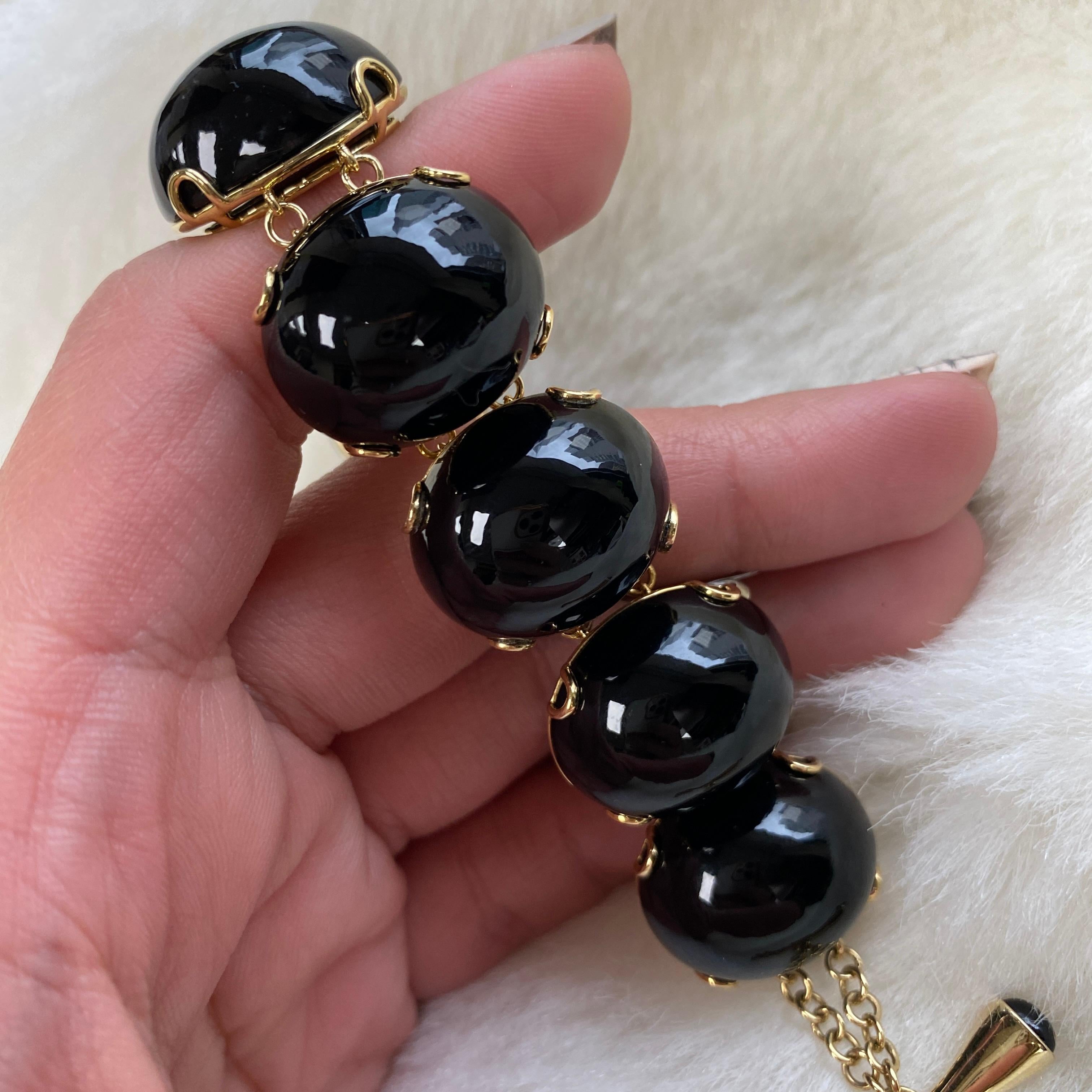 This Onyx Oval Cabochon Bracelet in 18K Yellow Gold is a captivating piece of jewelry that is part of the exclusive 'Rock 'N Roll' Collection. Crafted with meticulous attention to detail, this bracelet features mesmerizing oval-shaped Onyx cabochon