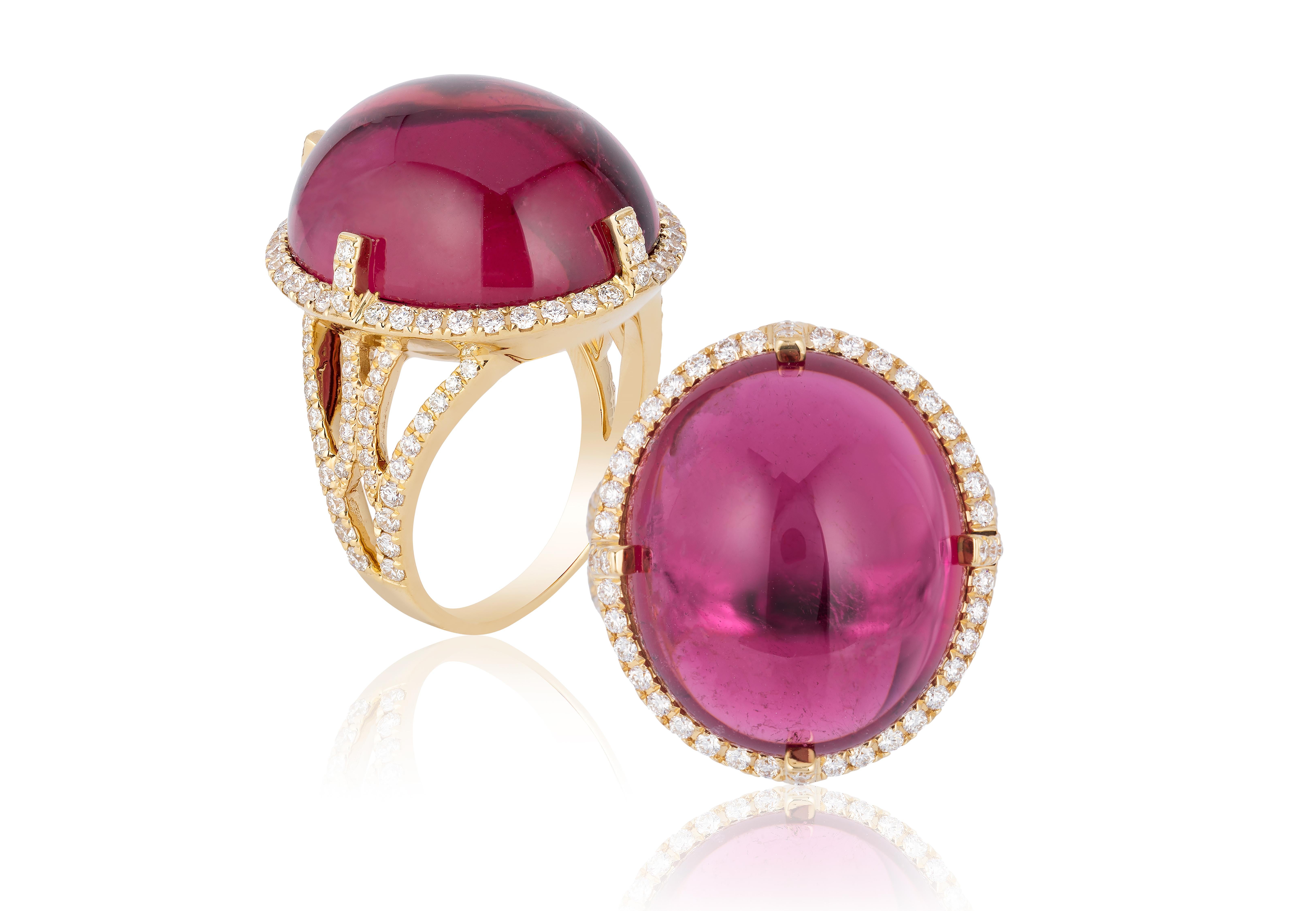 This Oval Rubelite Cabochon Ring is a striking piece from the 'G-One' Collection. Made of 18K yellow gold, it features a mesmerizing oval rubelite cabochon at its center with diamonds around. Also There's diamonds in the band, adding subtle elegance