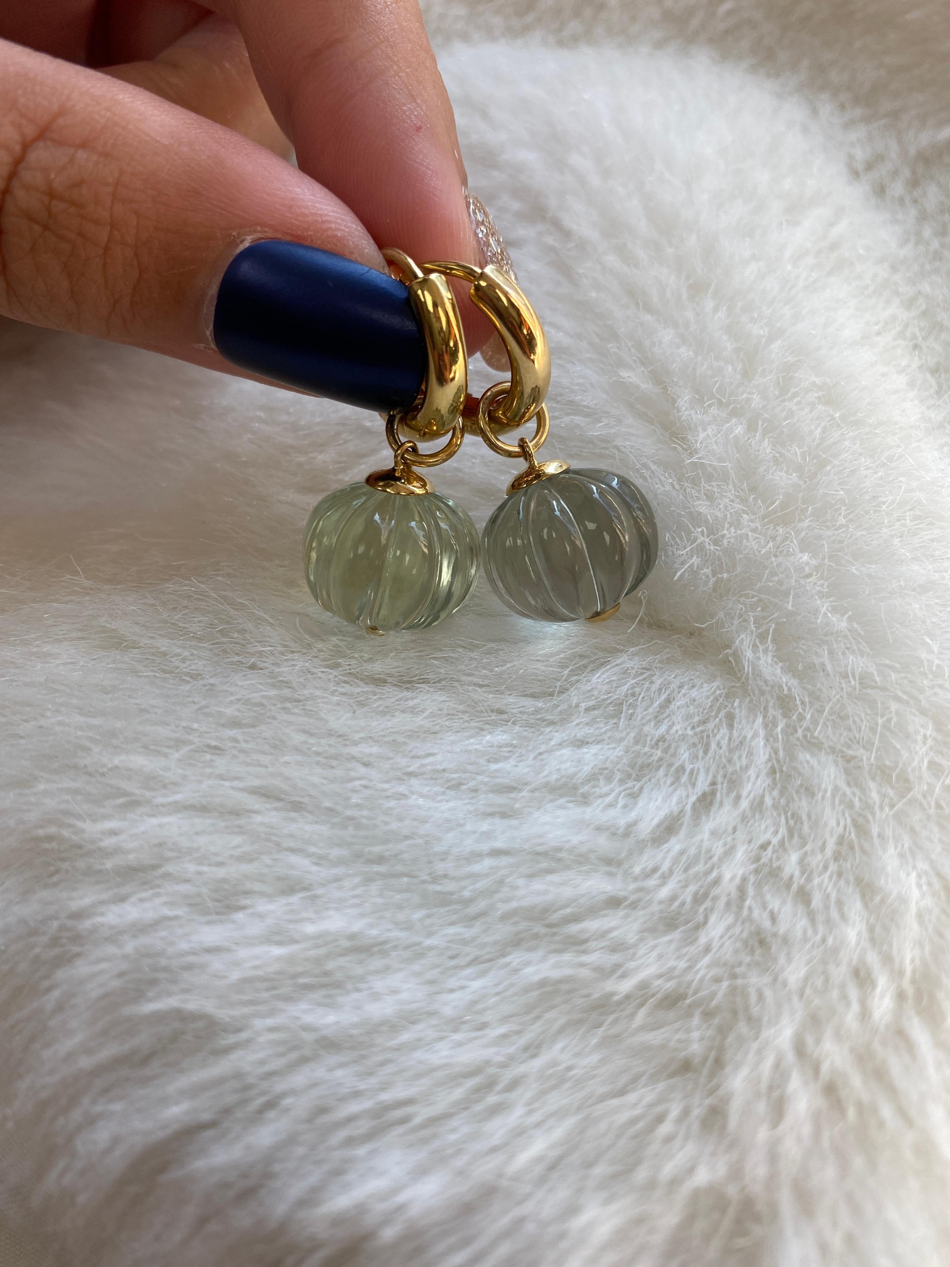 The Prasiolite Fluted Round Bead Double Loop Earrings in 18K Yellow Gold are a stunning piece of jewelry that exudes elegance and sophistication. The earrings are crafted from high-quality 18K yellow gold, which gives them a rich and warm color that