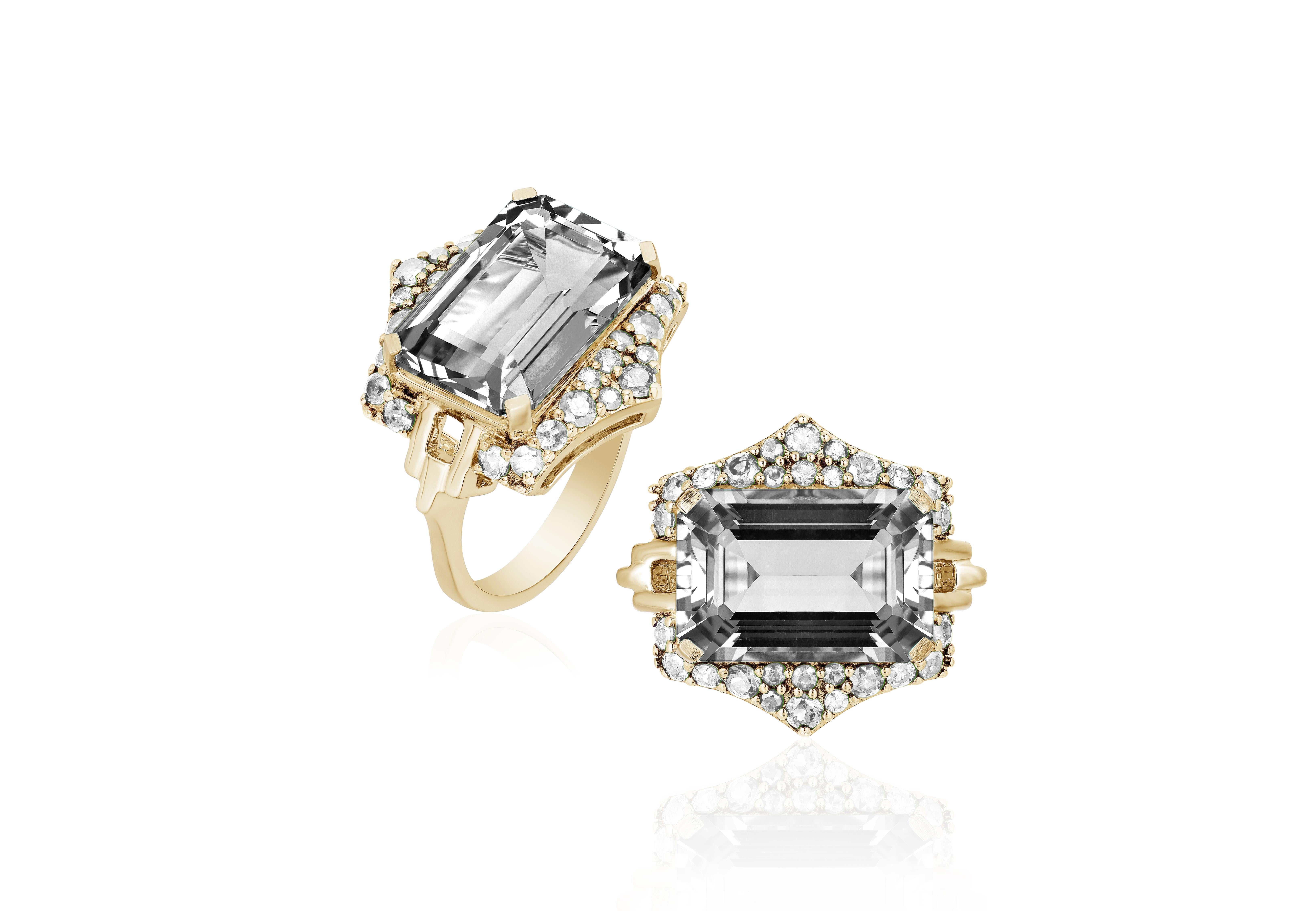 This Rock Crystal Emerald Cut Ring with Diamonds is a stunning piece of jewelry from the 'Rainforest' Collection. The ring is crafted from 18K yellow gold and features a beautiful emerald-cut rock crystal as its centerpiece, surrounded by sparkling