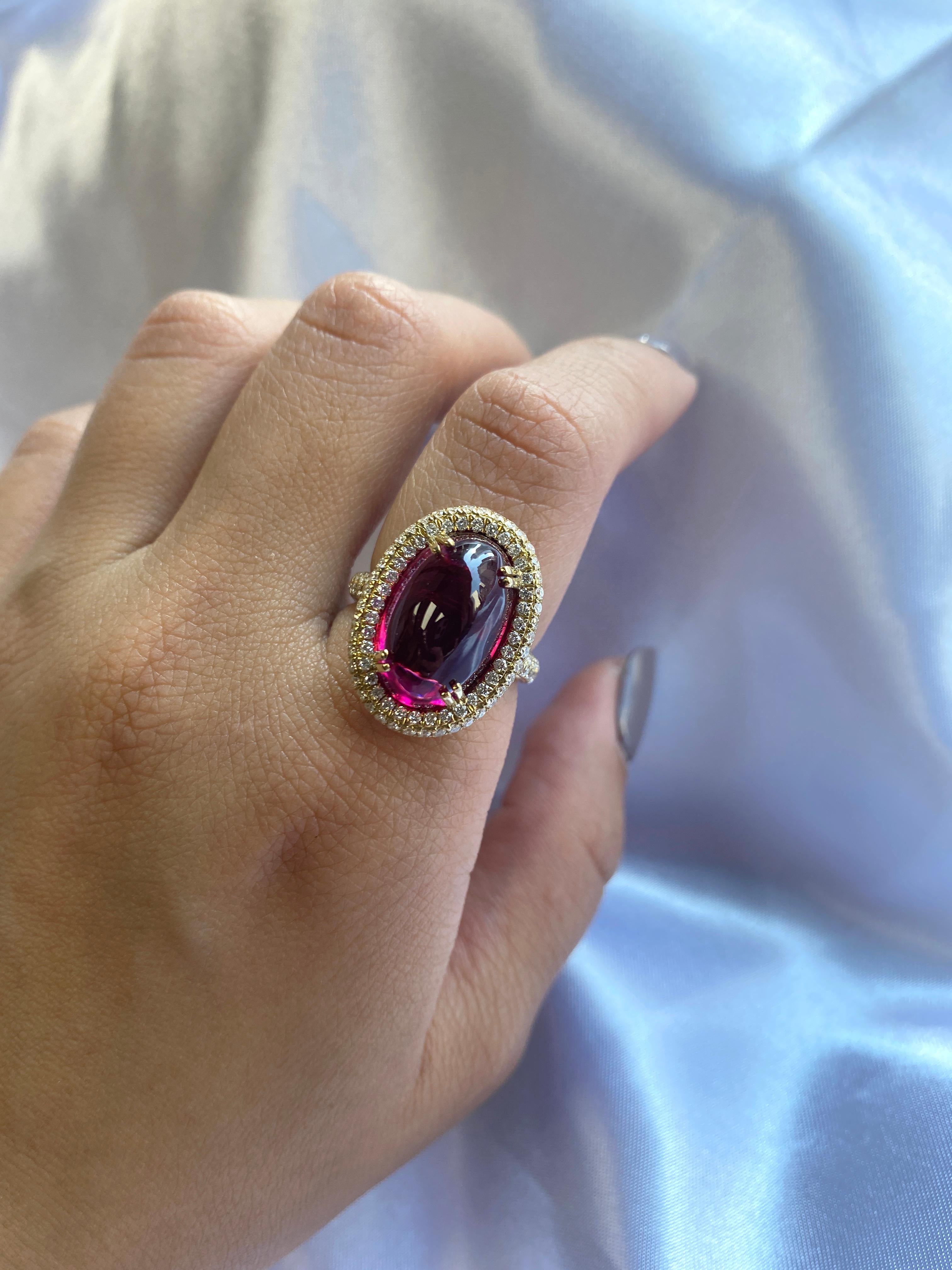 This Oval Rubelite Ring in 18K Yellow Gold from the 'G-One' Collection is an elegant piece that showcases an oval rubelite stone surrounded by diamonds. The rich hue of the rubelite is complemented by the brilliance of the diamonds, creating a