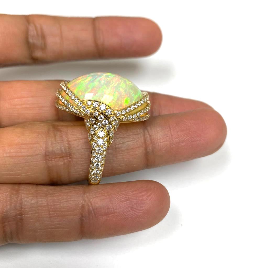 This Yellow Opal Cabochon Ring with Diamonds in 18K Yellow Gold is a stunning piece of jewelry from the 'G-One' Collection. The ring features a beautiful yellow opal cabochon set in 18K yellow gold, surrounded by dazzling diamonds. The opal's