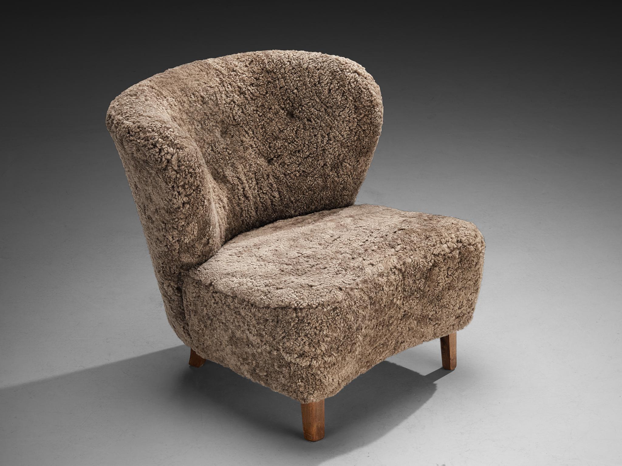 Gösta Jonsson, Sessel, Buche, Schafsfell, Dänemark, 1940er Jahre 

Ein charmanter Loungesessel von Gösta Jonsson, der von der strengen geometrischen Strenge abweicht und stattdessen eine weiche, skulpturale Qualität aufweist, die sowohl organisch