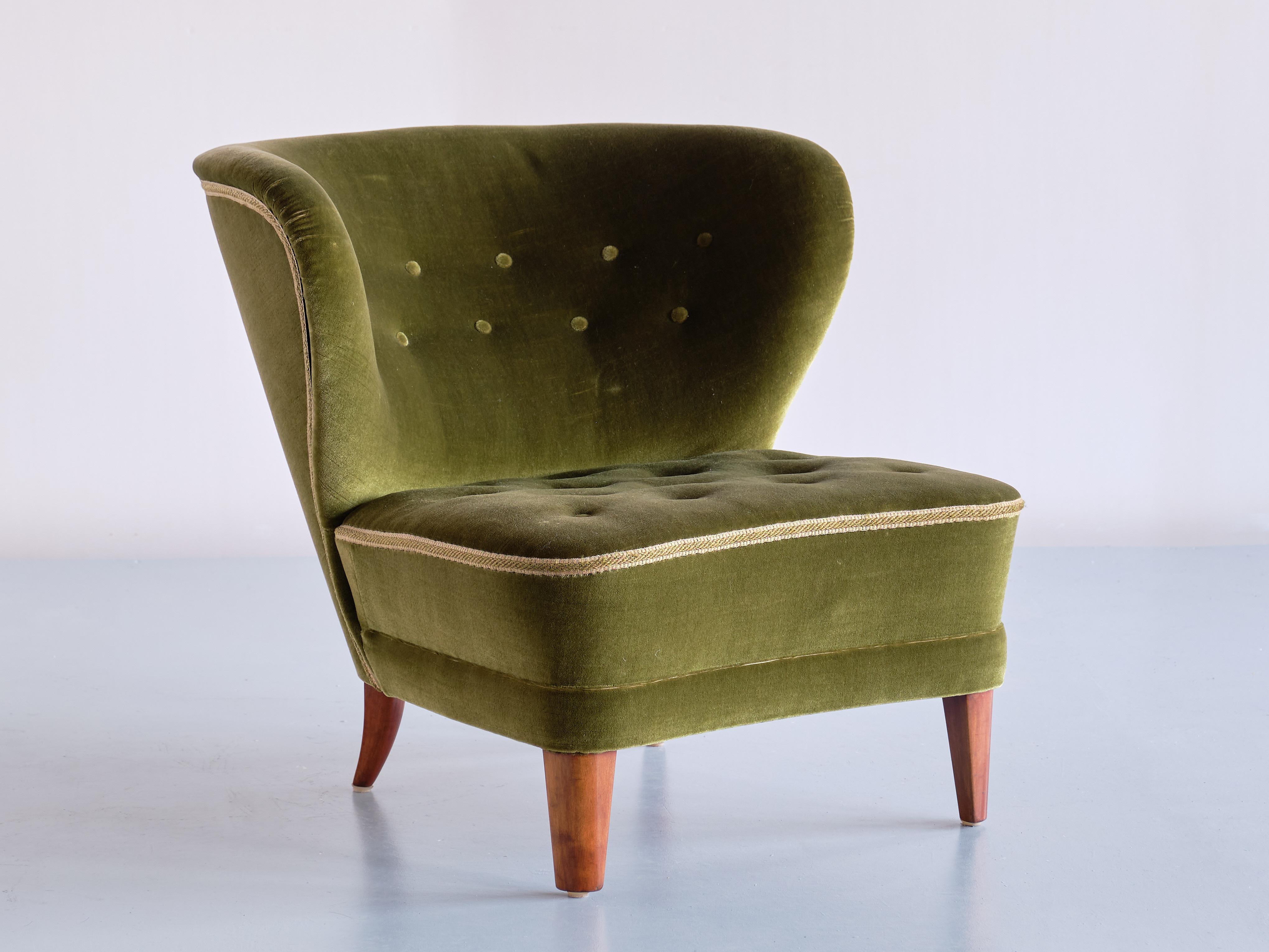 This rare lounge chair was designed by Gösta Jonsson and produced in Jönköping, Sweden in the late 1940s. The beautifully curved backrest with tufted buttons make this a very comfortable and embracing chair. 

The chair retains it's original green