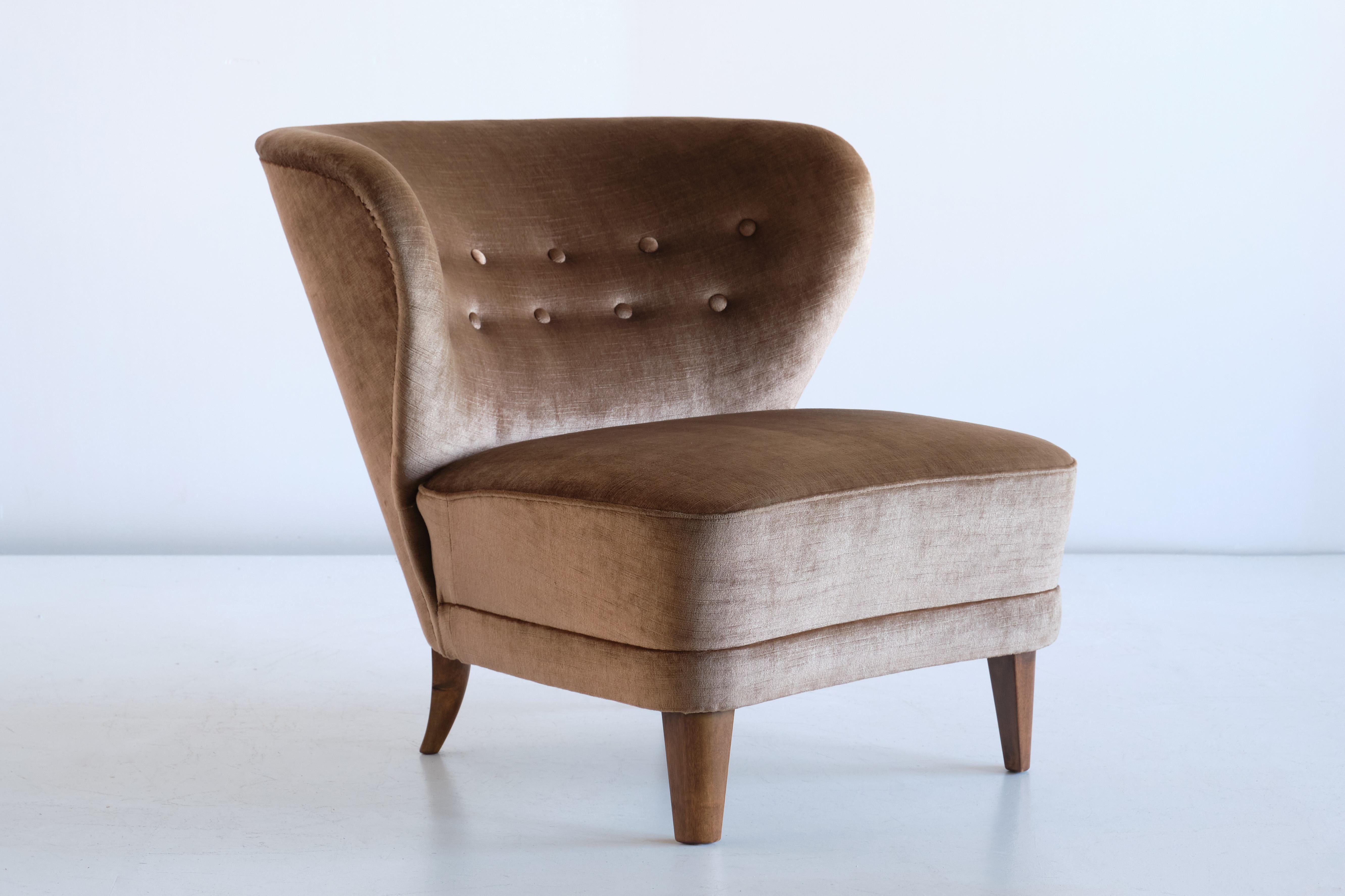 This rare lounge chair was designed by Gösta Jonsson and produced in Jönköping, Sweden in the late 1940s. The beautifully curved backrest with tufted buttons make this a very comfortable and embracing chair. The original brown velvet upholstery has
