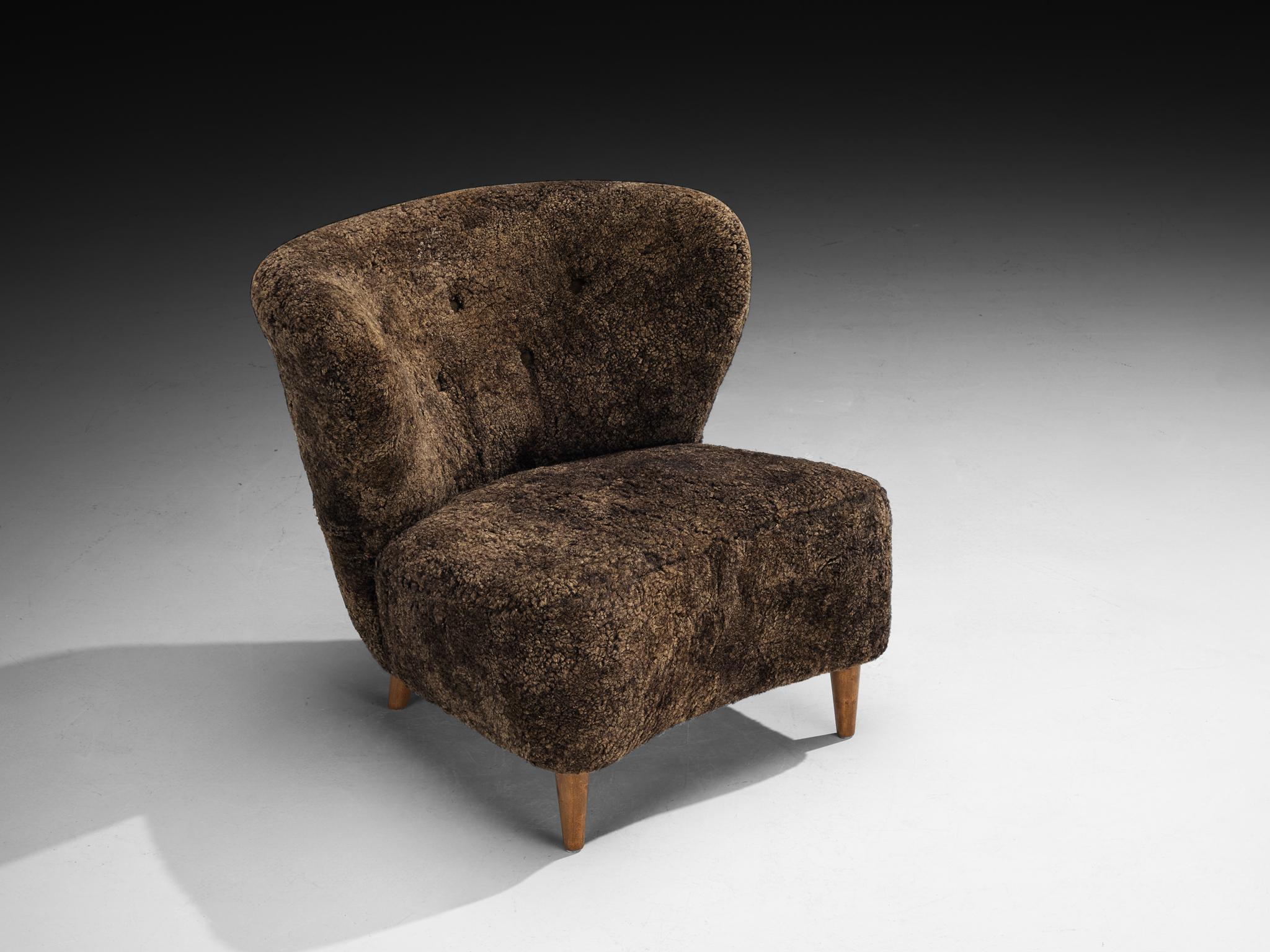 Gösta Jonsson Pareja de sillones de piel de oveja marrón oscuro mediados del siglo XX en venta