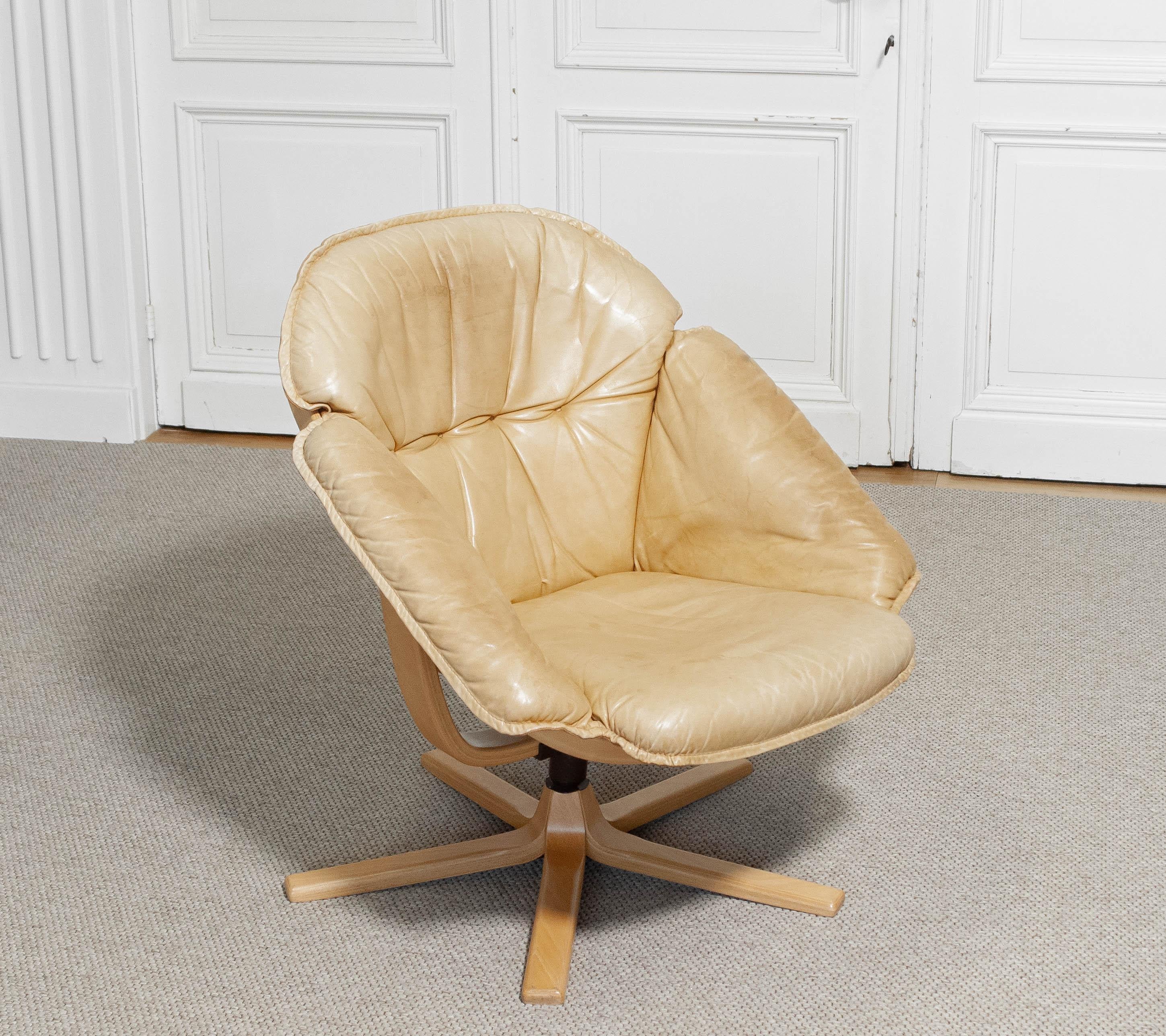 Stylish swivel lounge chair by Göte Möbel, Sweden, dating from the 1970s. The chair features a sculptural frame in light bentwood, supporting a generously padded seat and backrest upholstered in soft camel-colored leather.
The ergonomic design