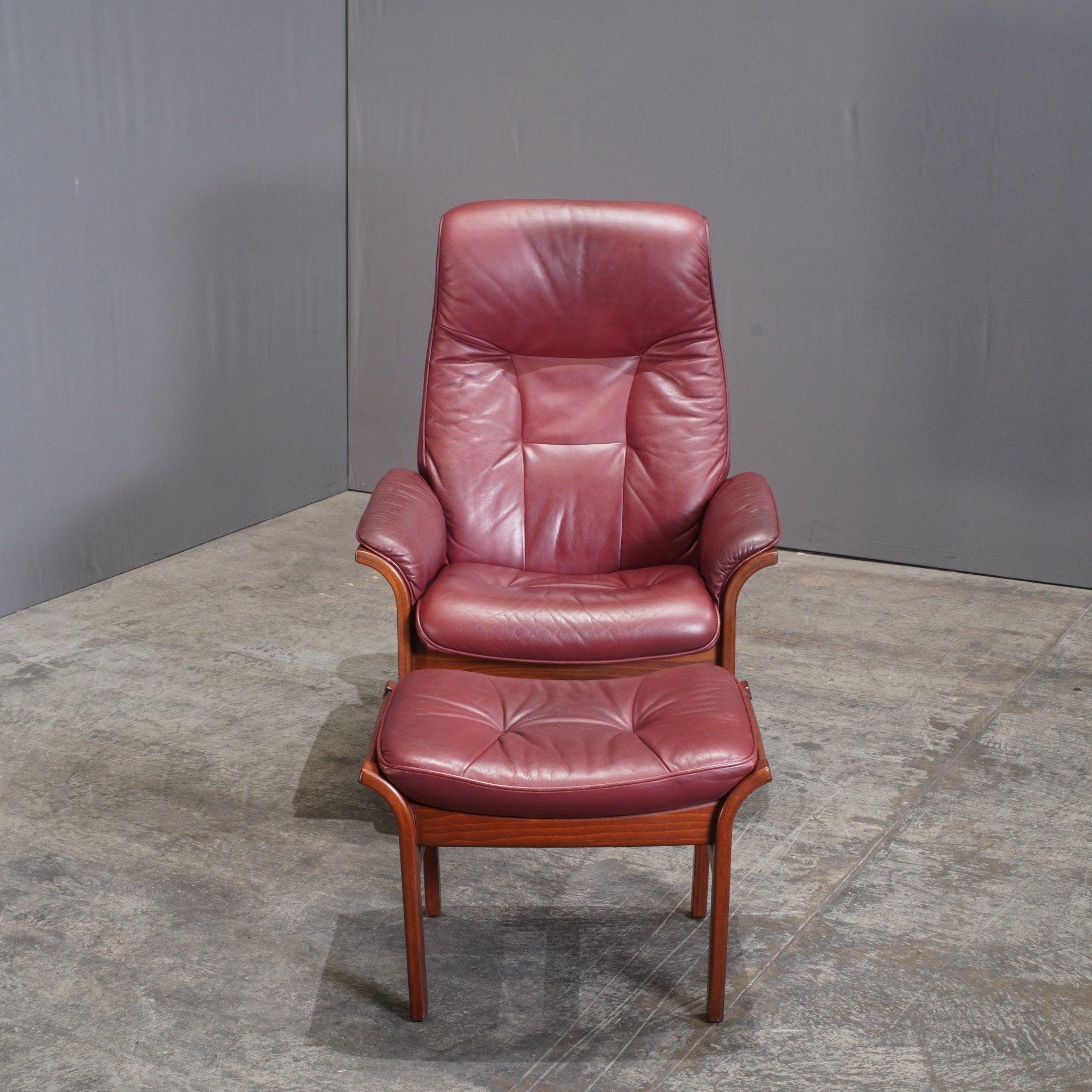 The Göte Möbler G Design Reclining Chair & Footstool is a striking example of Scandinavian craftsmanship, combining functionality with timeless elegance. The chair, upholstered in rich burgundy leather, offers both comfort and style with its