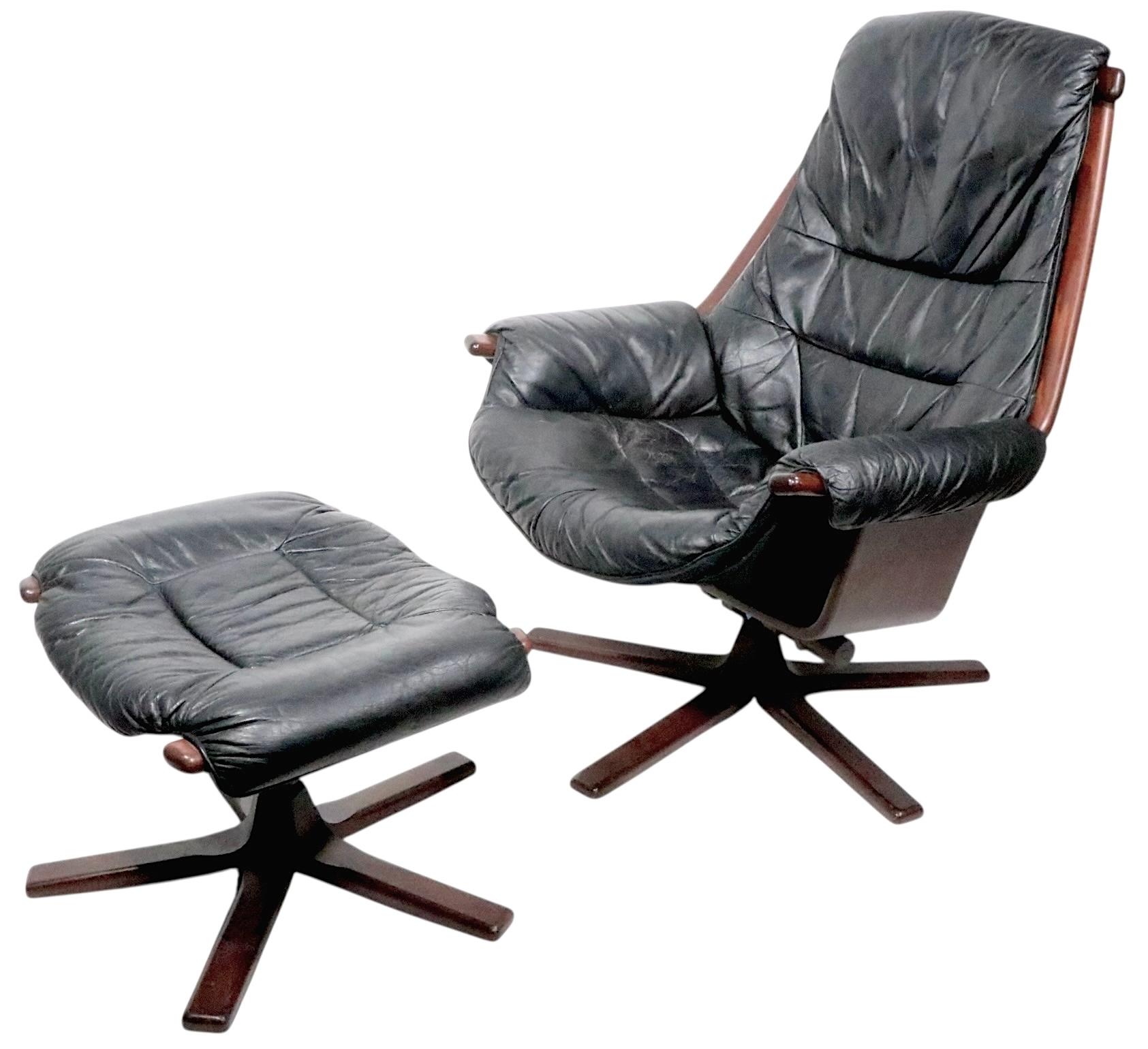 Außergewöhnlicher Mid-Century-Drehsessel mit passender Ottomane, in originaler schwarzer Lederpolsterung. Der Loungesessel ist drehbar und verfügt über einen Feststellmechanismus, die Ottomane ist ebenfalls drehbar. Dies ist ein klassisches Beispiel