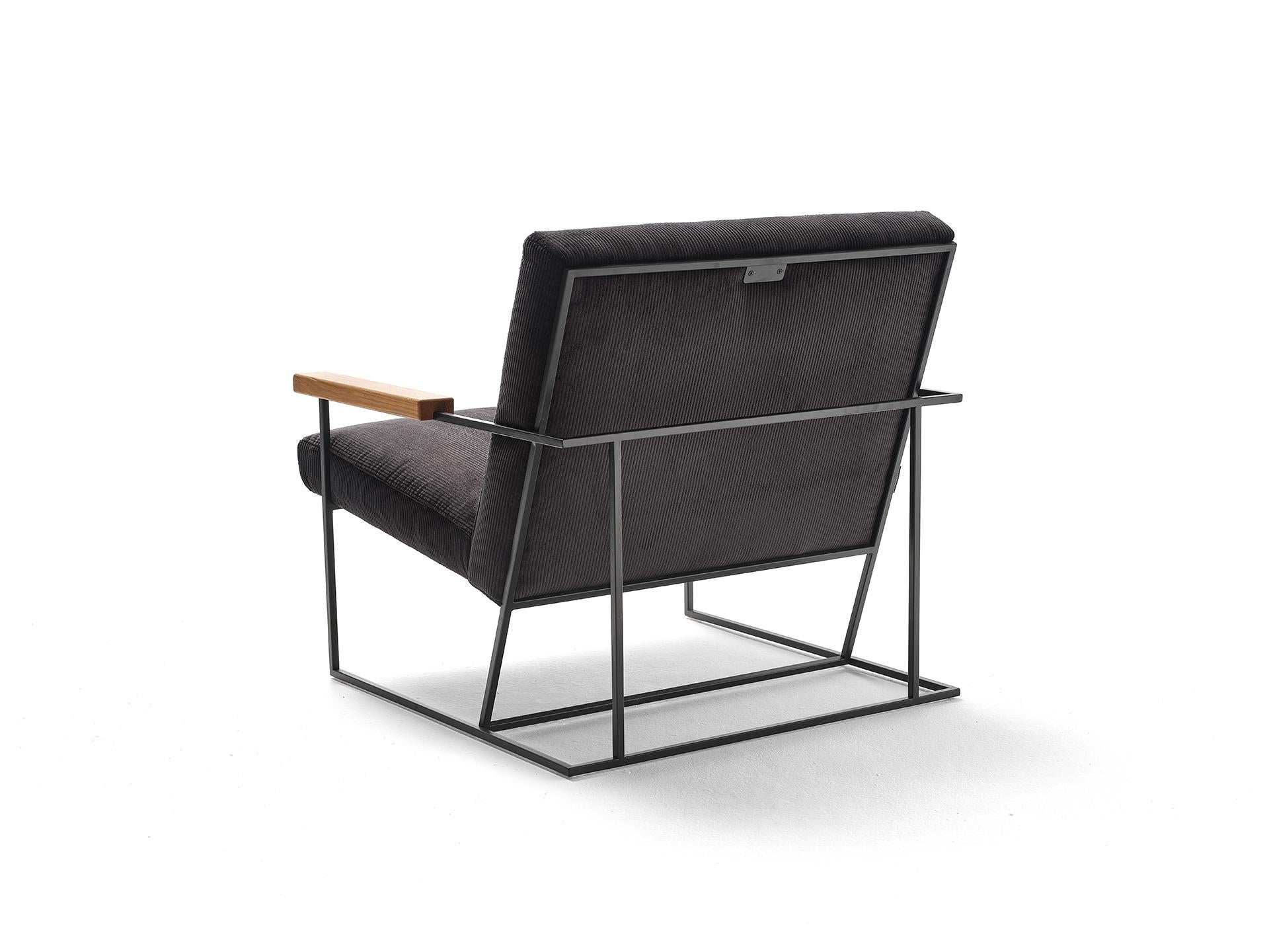 The distinctive linear geometry and the visual lightness of the Gotham armchair come from its metal frame, a clean aerial structure that holds the seat and backrest cushions. These in contrast are generous and voluminous thus creating a visual