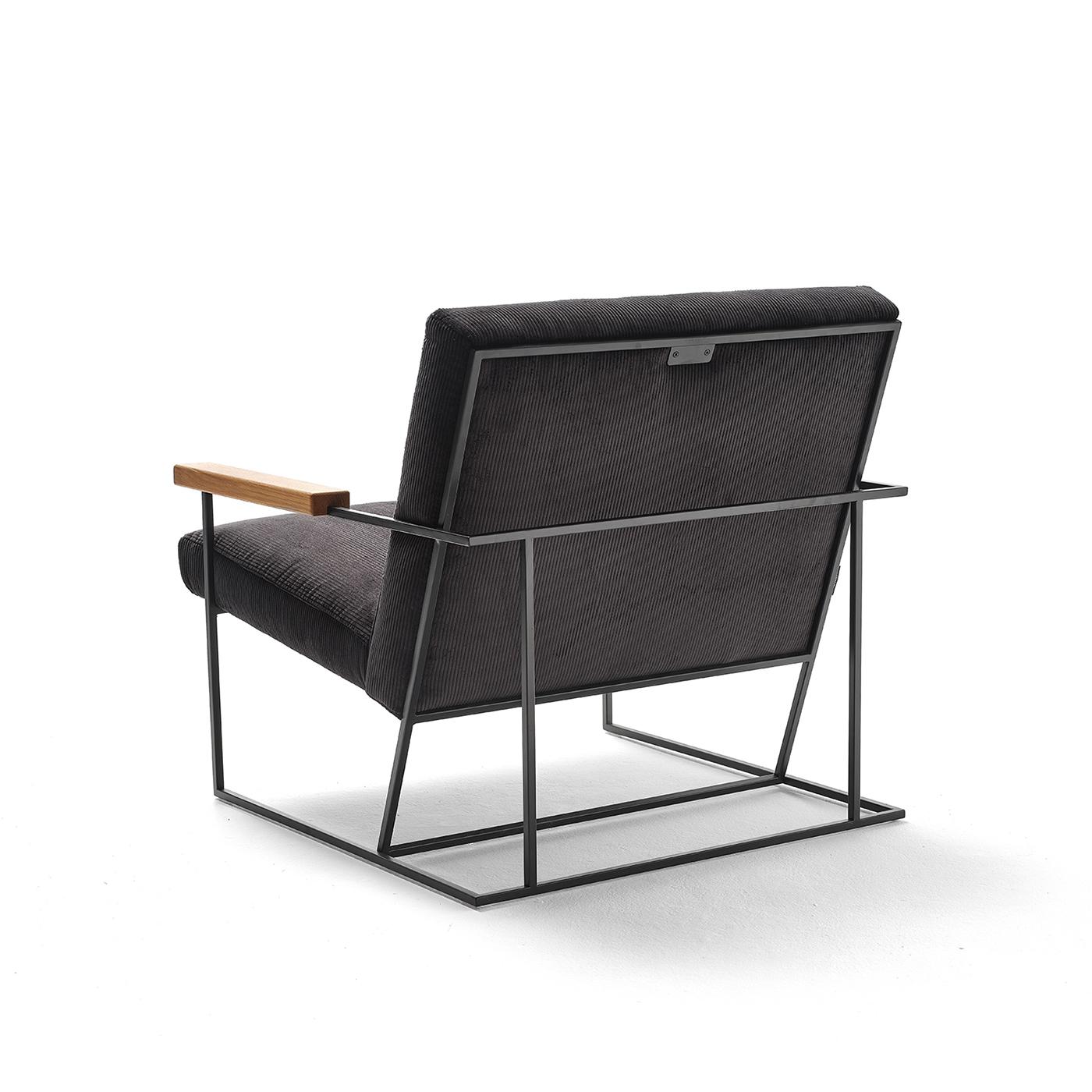 Perfectly balanced solids and voids masterfully define the elegant aesthetic of this armchair. Raised on a thin and graceful base in black-lacquered steel, the wide and welcoming seat is flanked by two sleek armrests in solid oak which extend to
