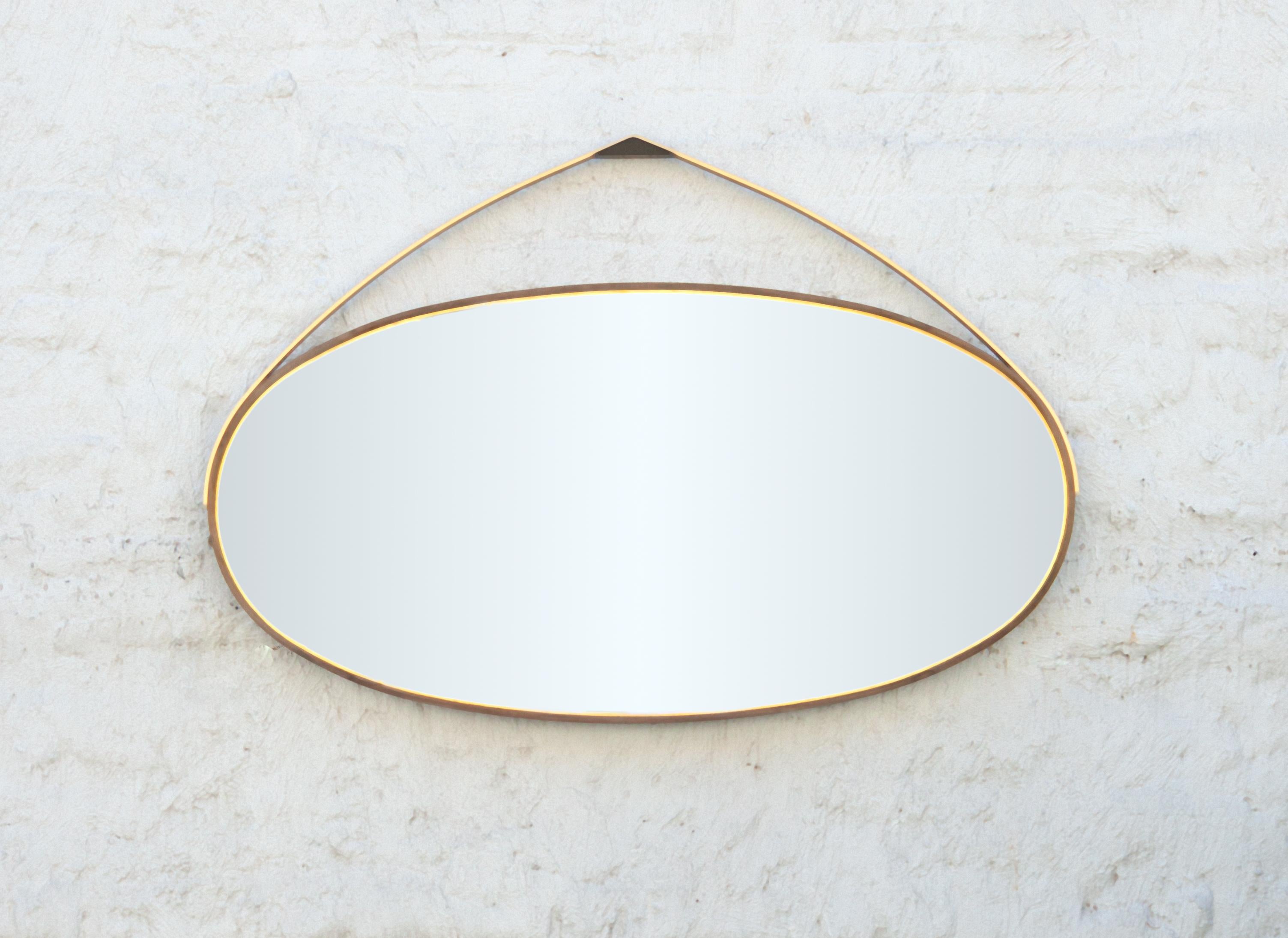 Faisant partie de la collection Gotham, ce miroir ovale fabriqué à la main présente une incrustation de feuilles de bronze, un cadre en érable Ambrosia oxydé plié à la vapeur et une structure de suspension en bronze tournée à la main, créant des