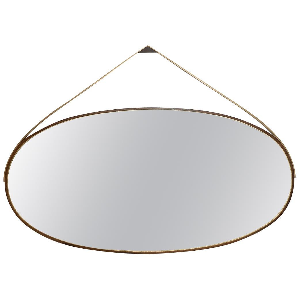 A band of oxidized ambrosia maple envelops our Gotham Oval mirror, a timeless piece that can marry with nearly any interior design (no surprise it’s our most popular style). The mirror itself lies atop gold leaf—skillfully placed by artisan makers.