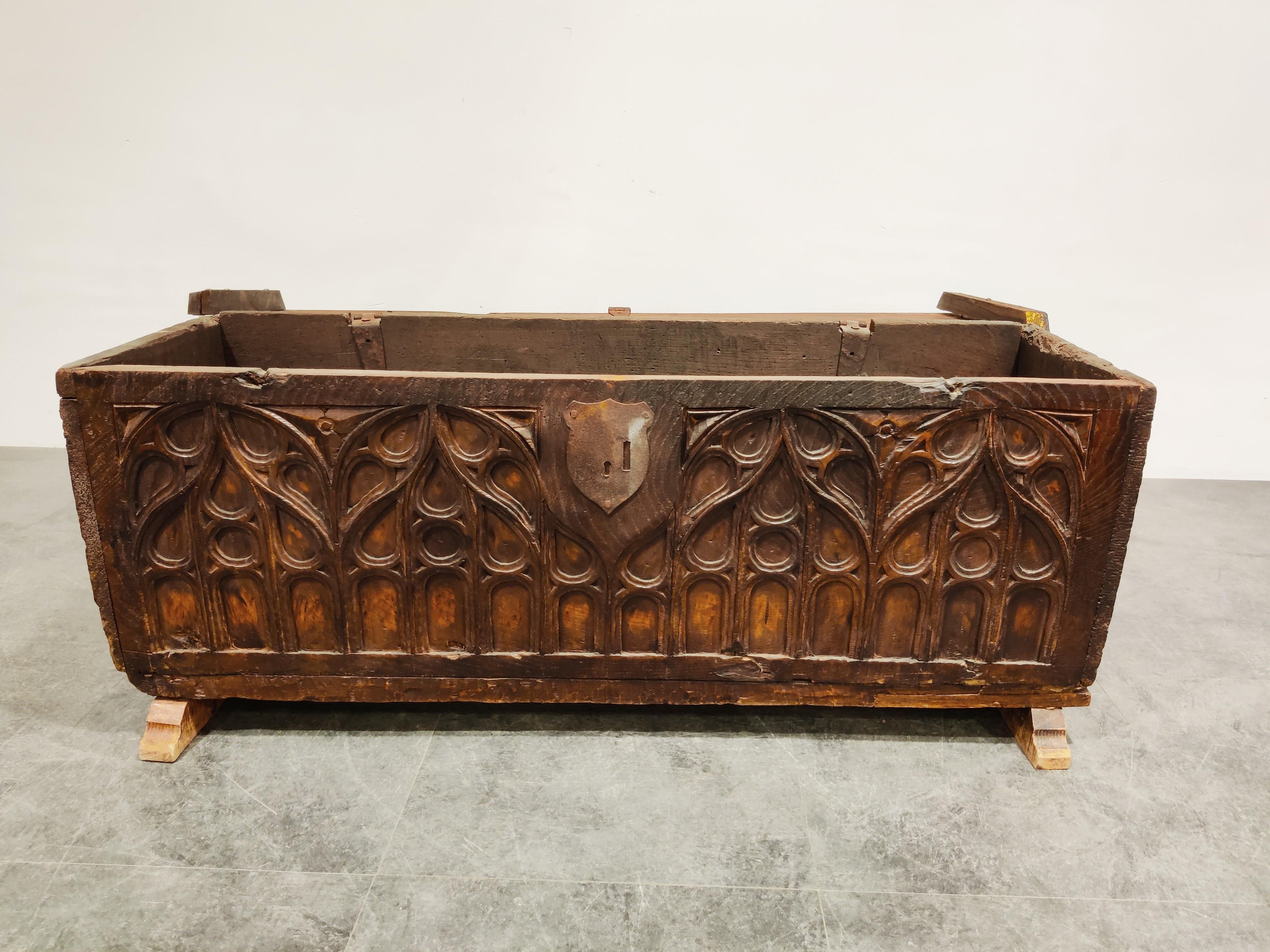 Antique 16th century blanket chest with Gothic carvings made from elm wood.

The hinged lid above a front panel with wrought iron hasp and three ogee lancet panels carved with tracery, on sledge feet.

The chest is made from various components,