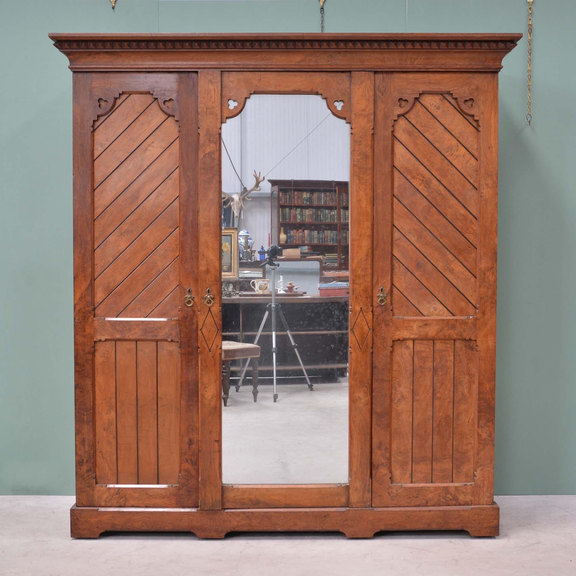 Victorian gothic Aesthetic Movement brown oak wardrobe by Marsh, Jones & Cribb
Well figured brown oak veneers with burr of good colour, elaborate stop chamfers and handles in the Aesthetic style.  The panelled doors on either side featuring the