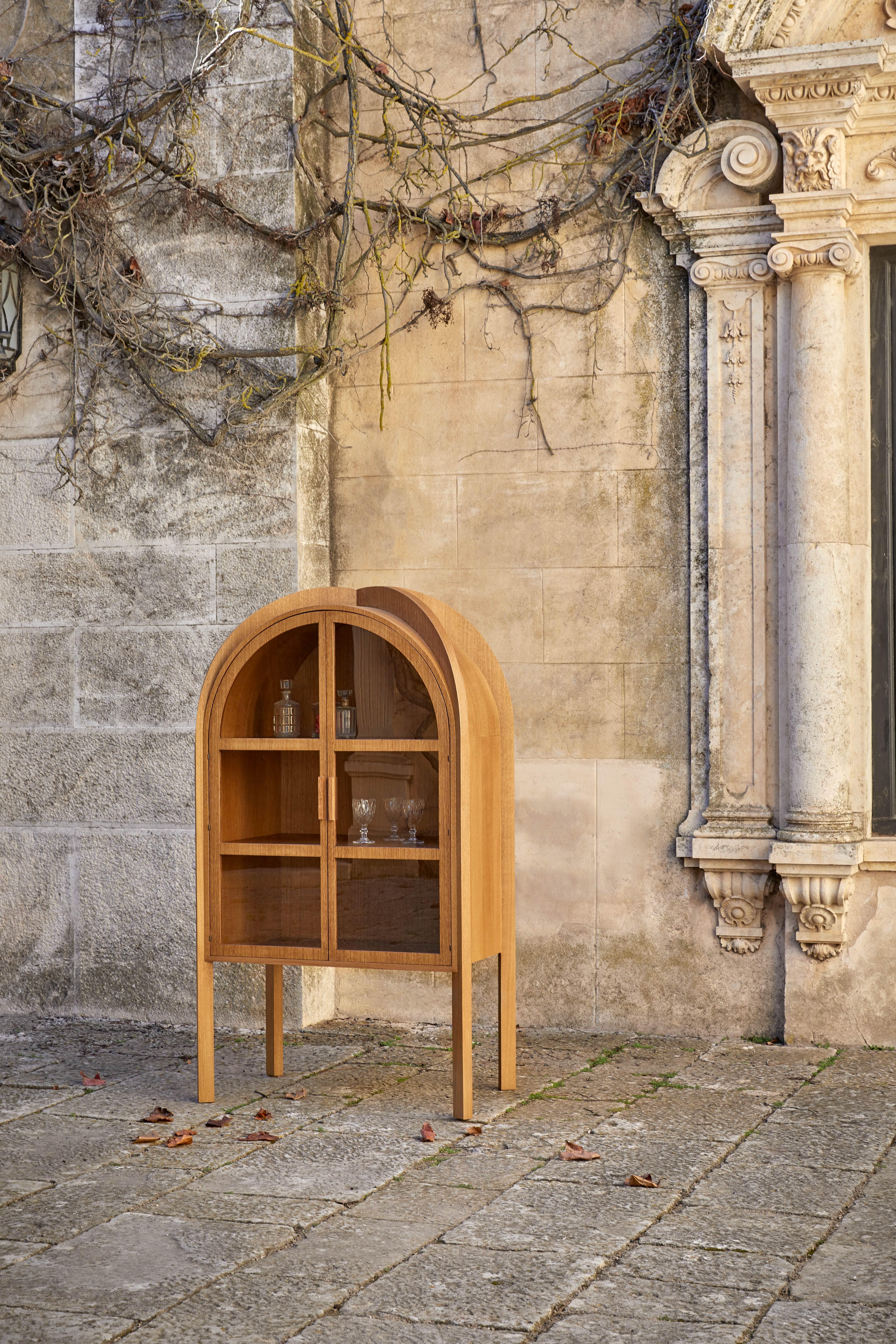 A reimagining of early Gothic architecture for the present day, this multi-use armoire has been exquisitely adapted for the contemporary lifestyle, with sensuous, soft curves that hint towards the Romanesque. The armoire features an apex adorned