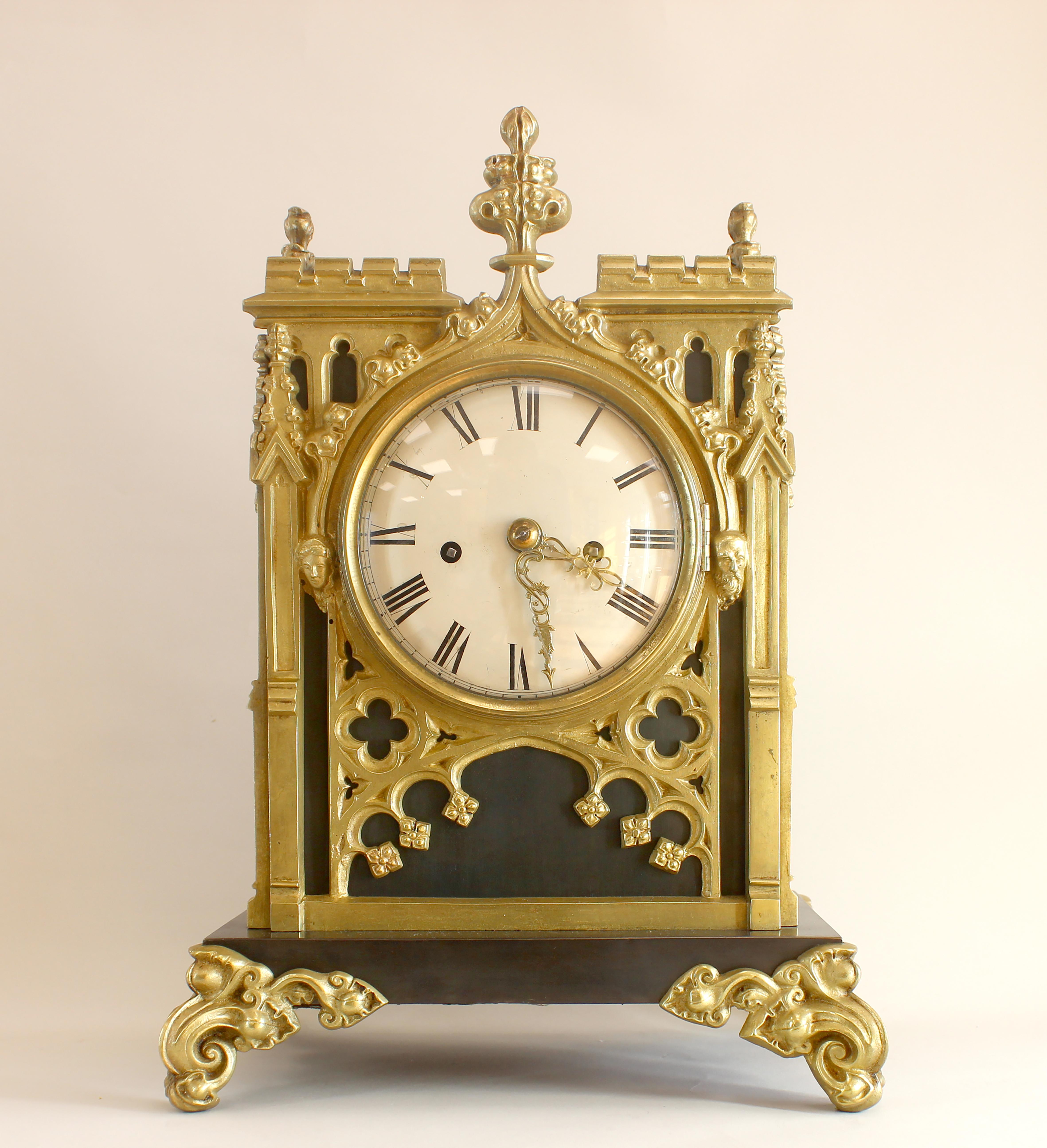 A gothic revival bronze and brass bracket clock with a 5-inch silvered convex Roman dial. The  twin fusee movement strikes on a bell, with a heavy high quality pendulum and hold fast. The case of crocketed lancet-arched design, pierced with