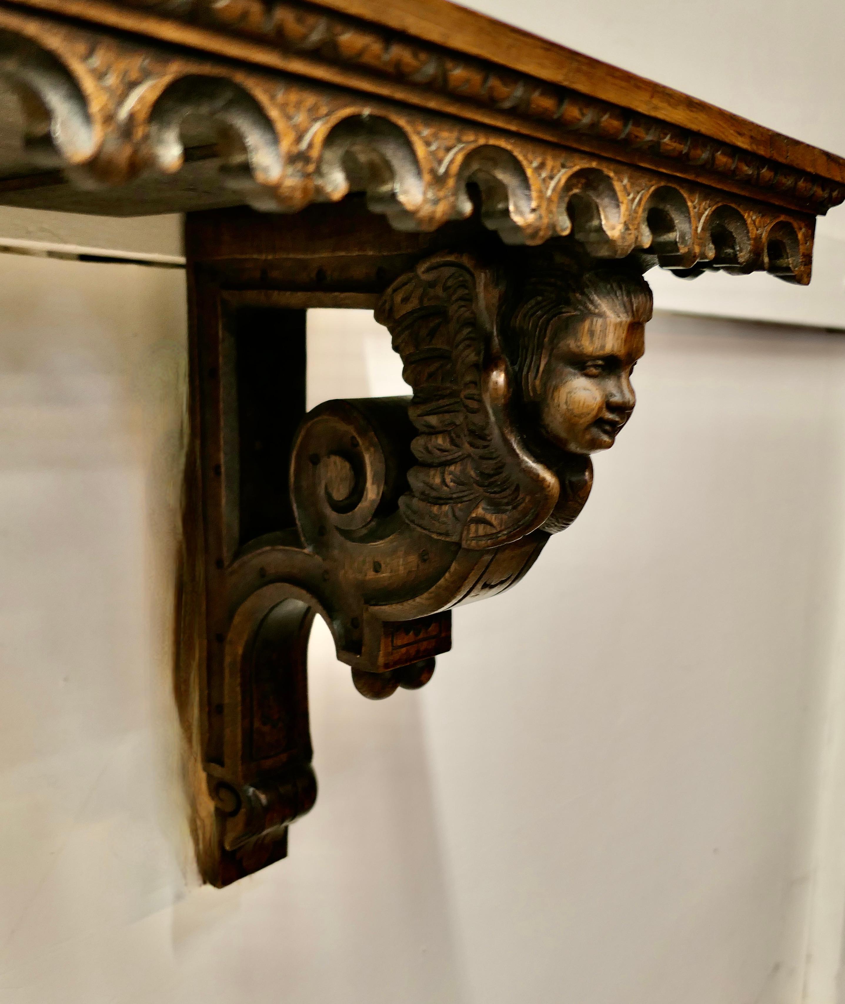 Gothic Carved Long Oak Wall Shelf 

This charming long shelf has side supports carved with caryatid or angels at each end, the shelf has a carved apron around the top edge

The Shelf is 11” deep, 65” long and 16” high
MS85