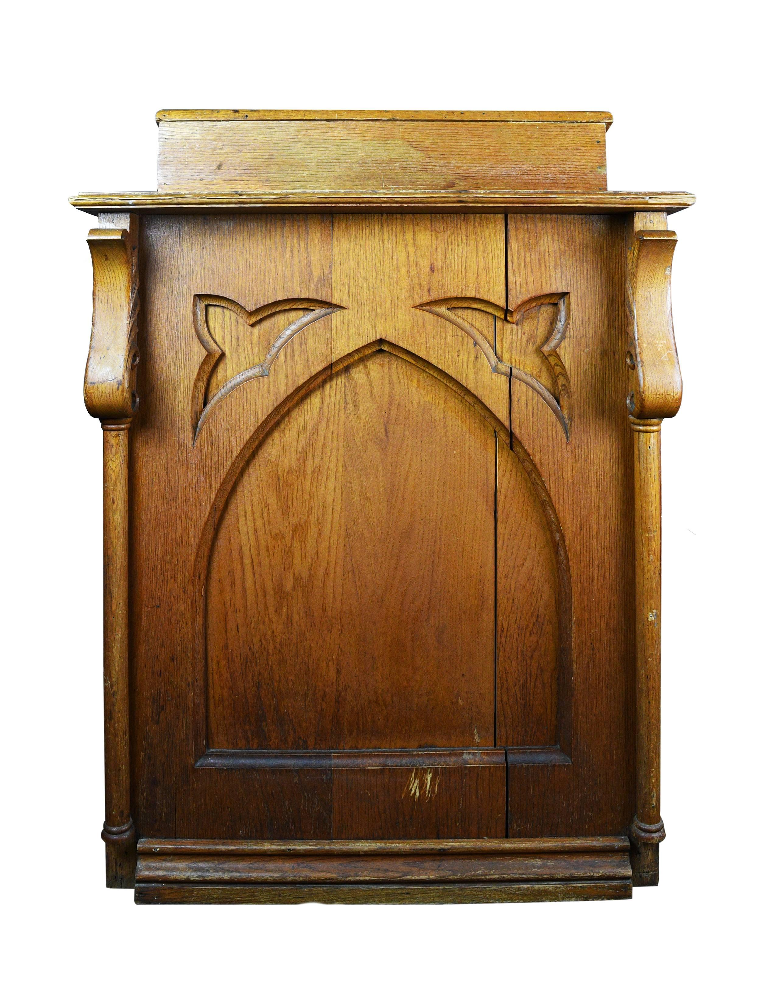 This wonderful Gothic carved oak lectern features a large, recessed lancet arch surrounded by trifoil designs on either side. Curving, leaf-like adornments flank either side, adding an organic touch. A crack, approximately 1/8” thick, runs along one