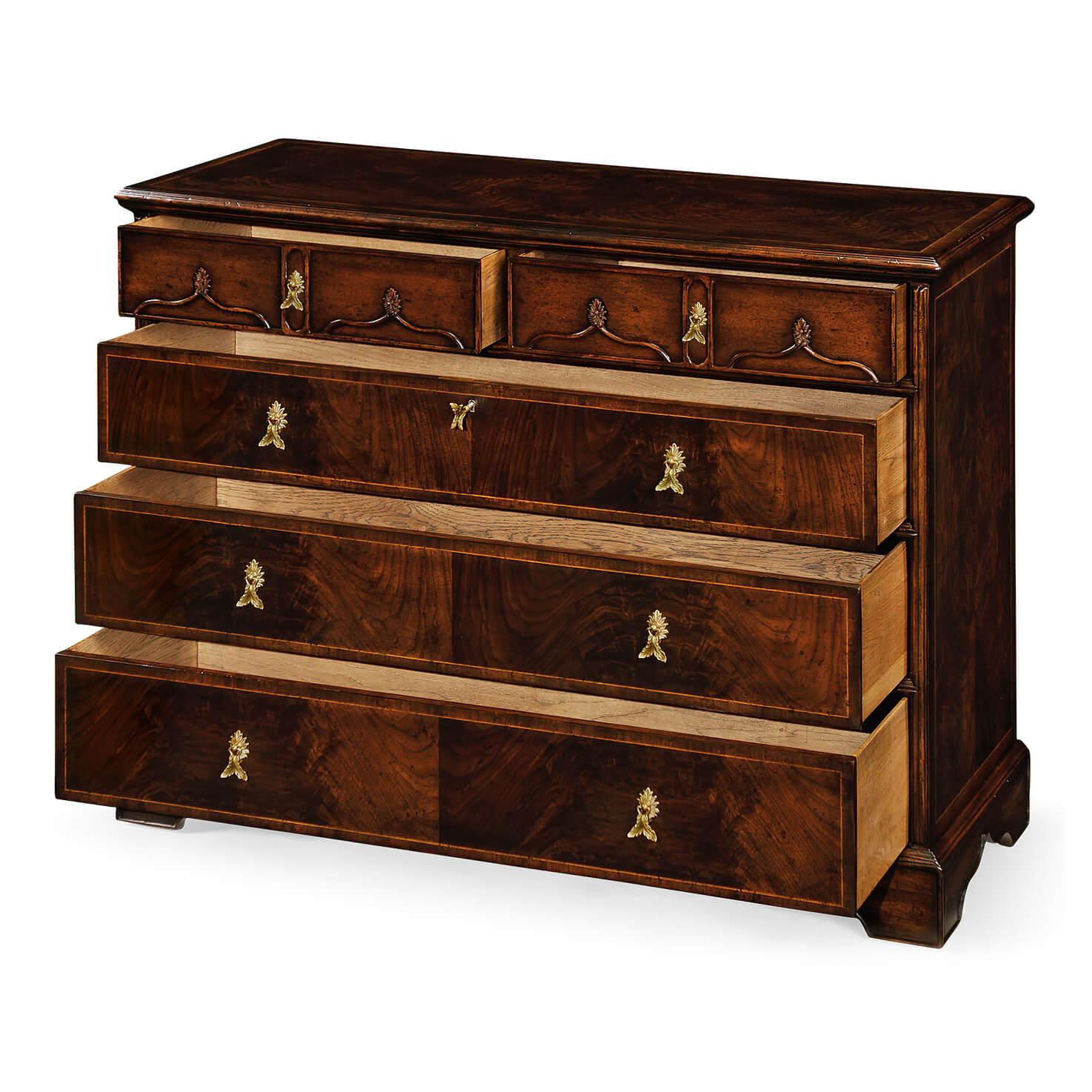 Chippendale gothic style large chest of five drawers with shallow carved ogee arches to the two top drawer fronts and with contrasting light stringing inlay. Finely cast brass handles. 

Dimensions: 48