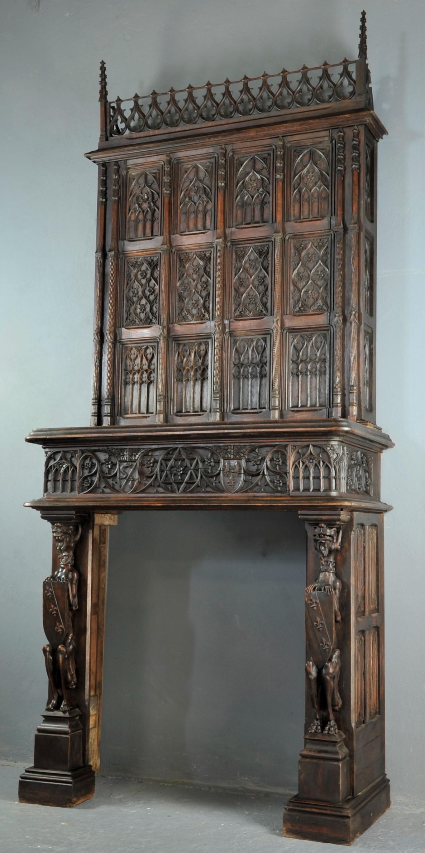 This delicately, rich carved Gothic fireplace dates back to the 17th century. Probably reassembled during the 19th century. The overmantel is decorated with 12 panels and on both sides are two slender columns. Panels are elaborately carved.  Columns