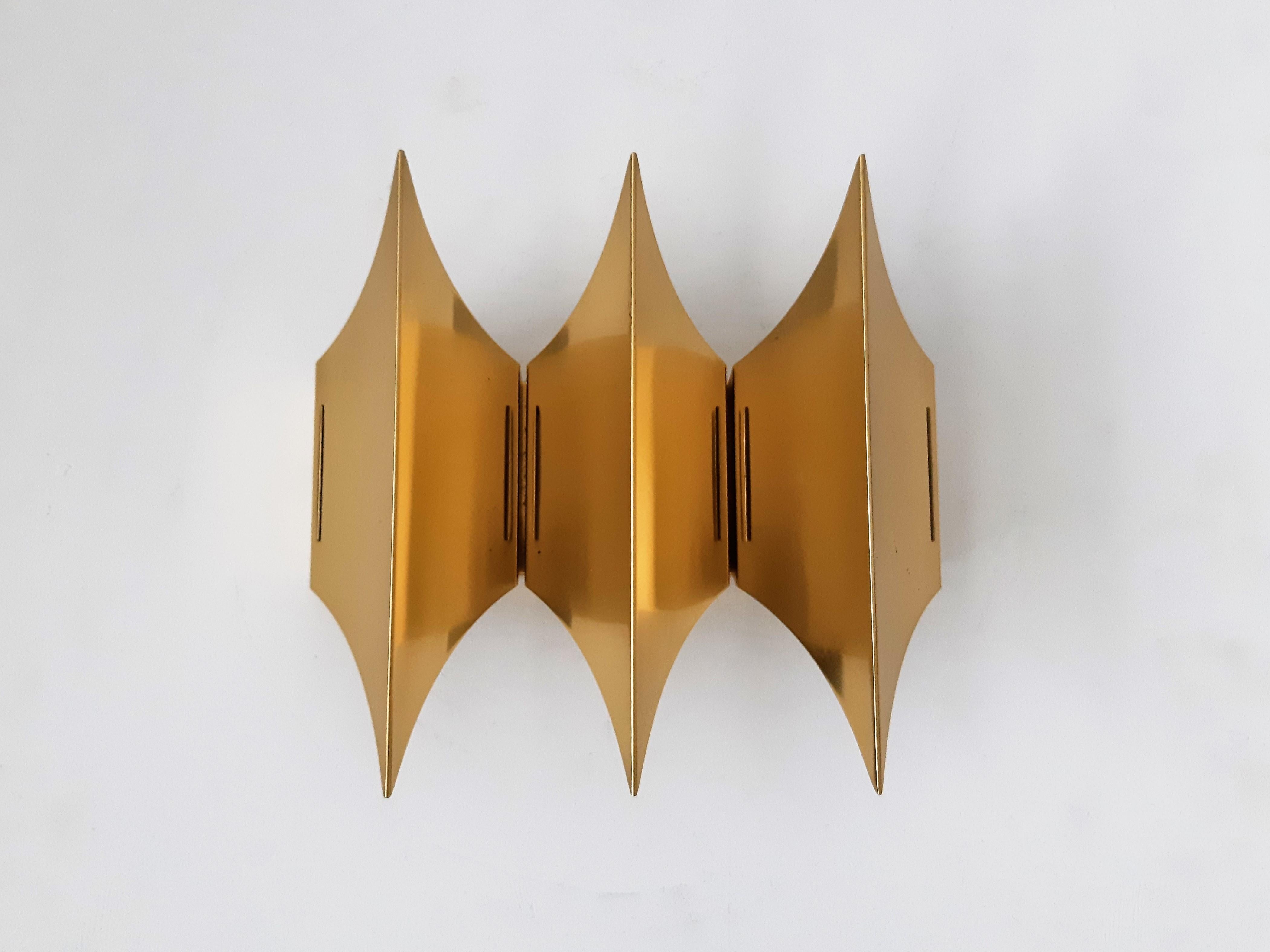 This fantastic Gothic III wall lamp was designed for Lyfa in the 1960's. It has a solid brass triplet shade, in the shape of the gothic architectural style that flourished throughout Europe from the 12th to the 16th century. It gives a beautiful and
