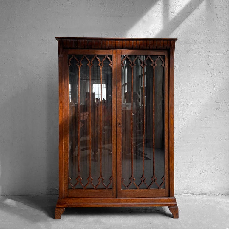 Antique, Gothic, carved oak, display cabinet features a glass front with decorative arched details. The paneled interior can accept either glass or wood shelves that can be provided if requested.