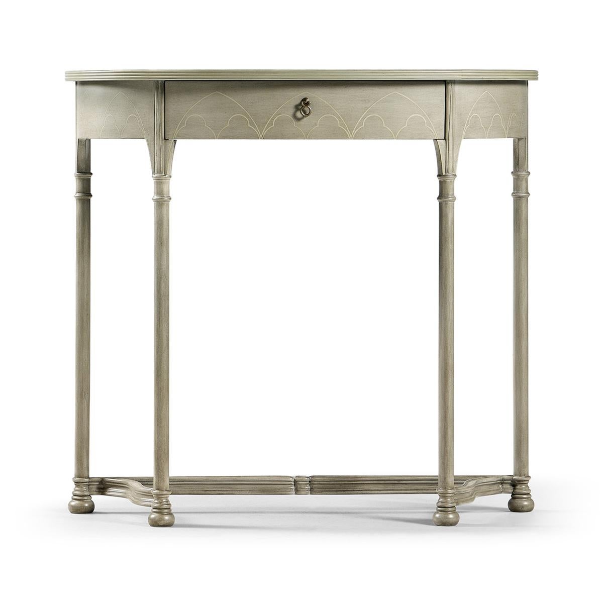 A Gothic painted console table with an antique grey finish, in an 18th-century gothic style, the demilune half-round form with fine contrasting inlays to the top and frieze, and legs with painted running floral motifs and arches.

Dimensions: 34