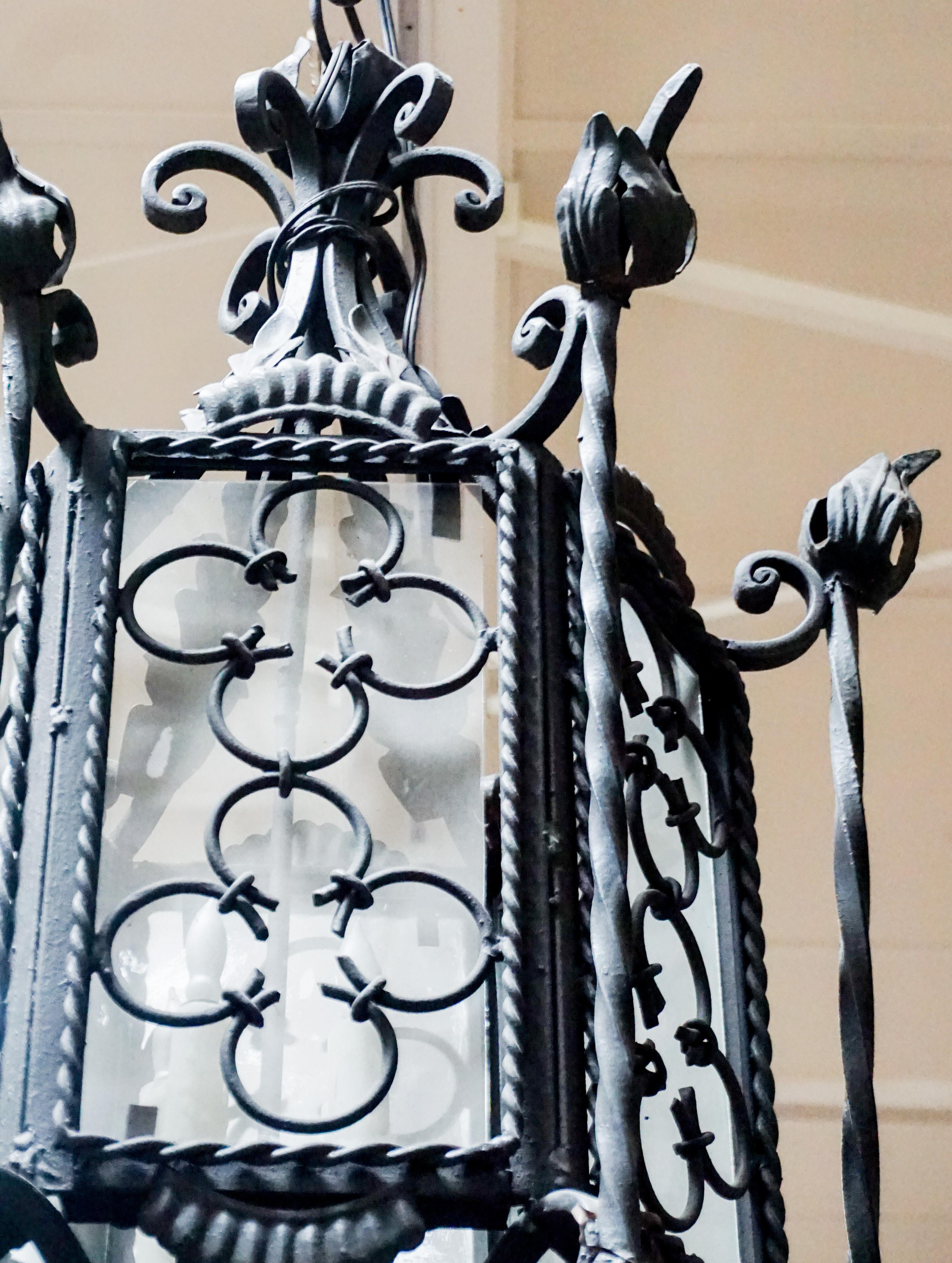 Medium handwrought iron hanging lantern with Gothic quatrefoil motif.