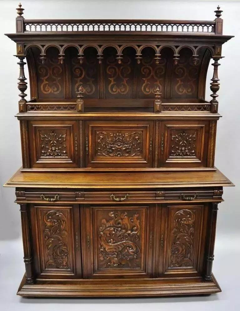 Gothic Renaissance Revival Carved Walnut Dragon Griffin Sideboard Buffet Cabinet. Item features two-part construction with ornate carvings throughout including dragons/griffins and flame and acanthus leafy scroll work. Sideboard has an impressive