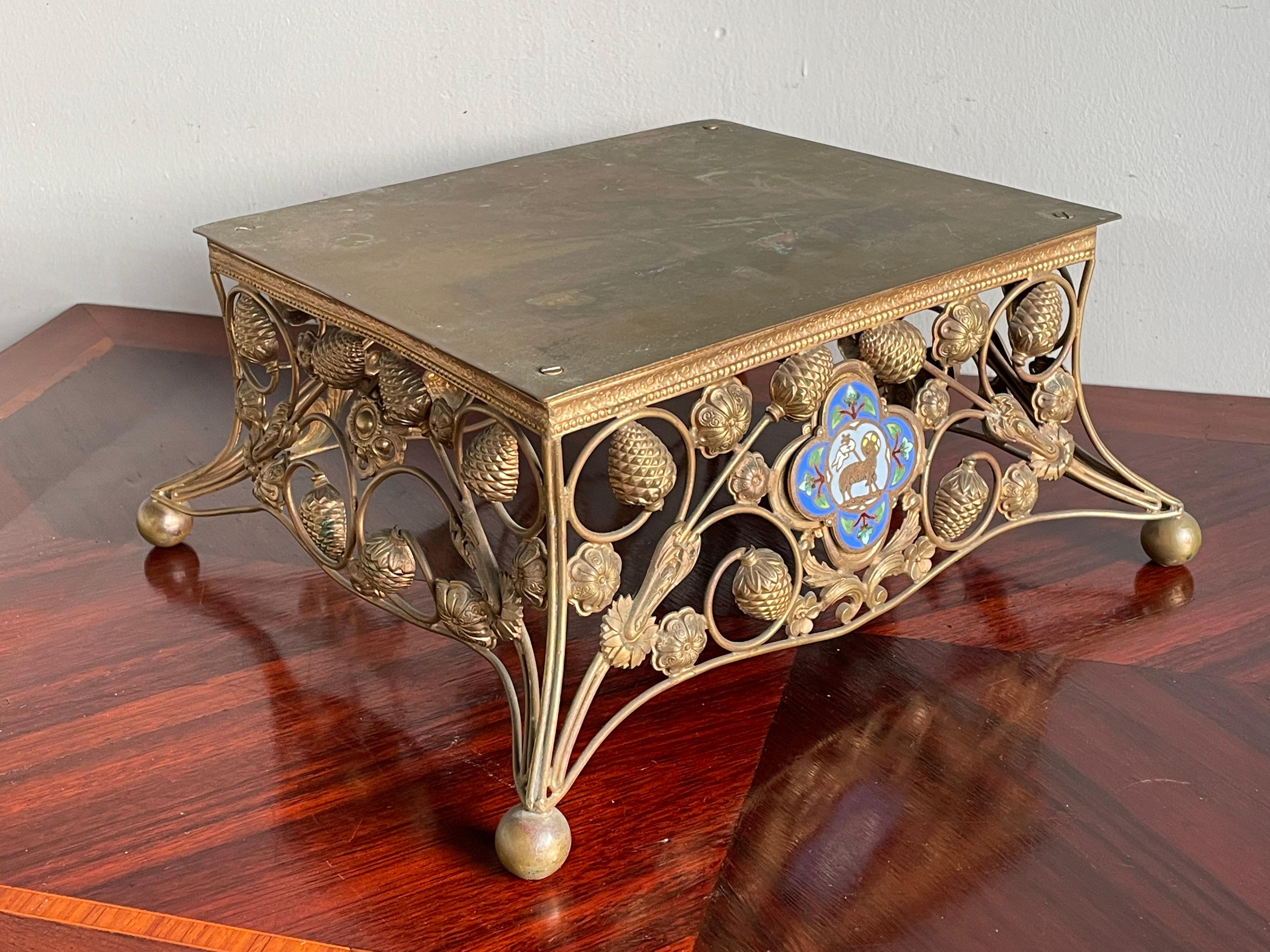 Rare 19th century Gothic church altar stand with cloisonné Agnus Dei symbol in a bronze quatrefoil.

This rare, late 1800s, brass sculpture stand has a multitude of beautiful details and it is in remarkably good condition. The stunning, open