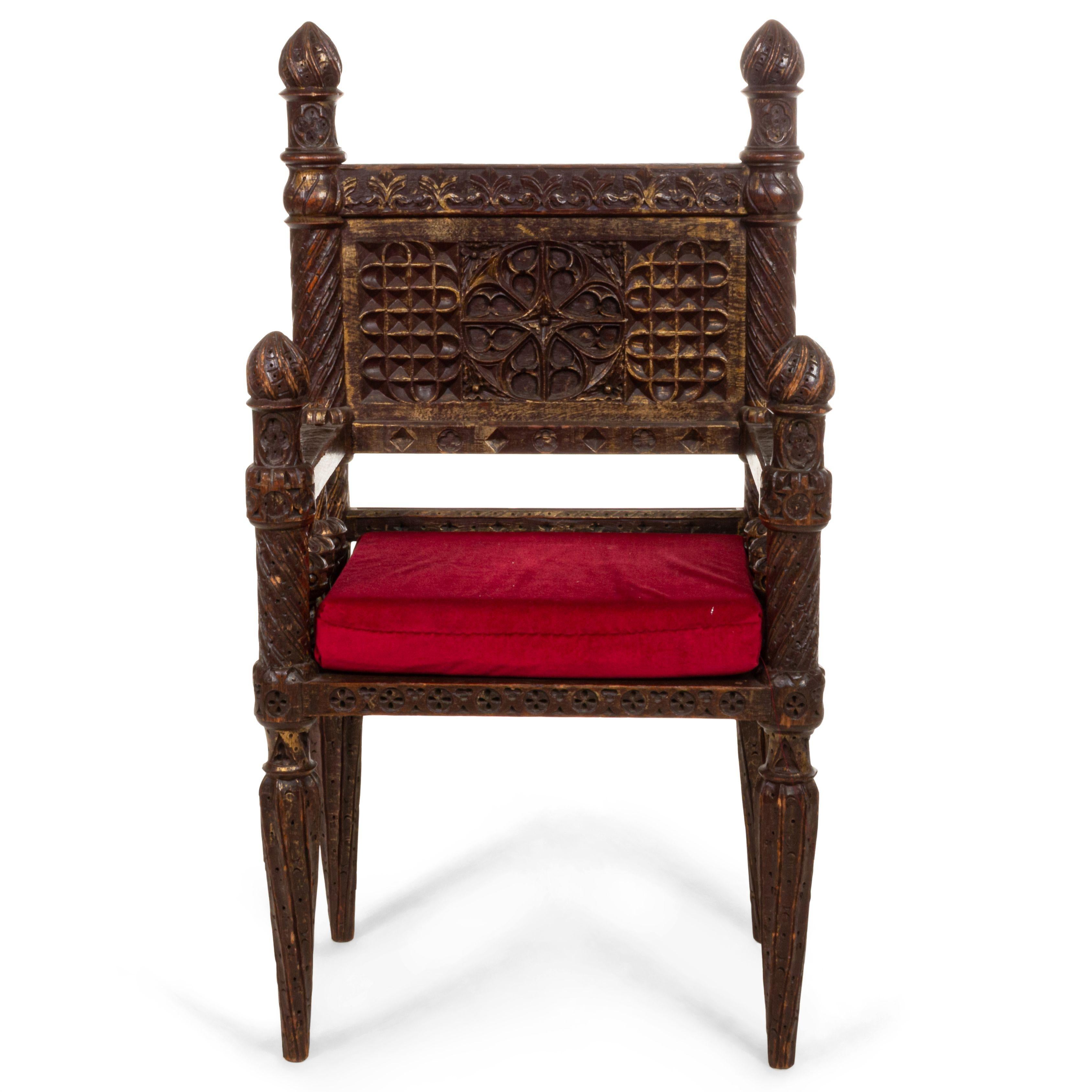 English Victorian Gothic Revival style carved burgundy painted and gold trim small (throne) armchair with carved center medallion and finials on back.