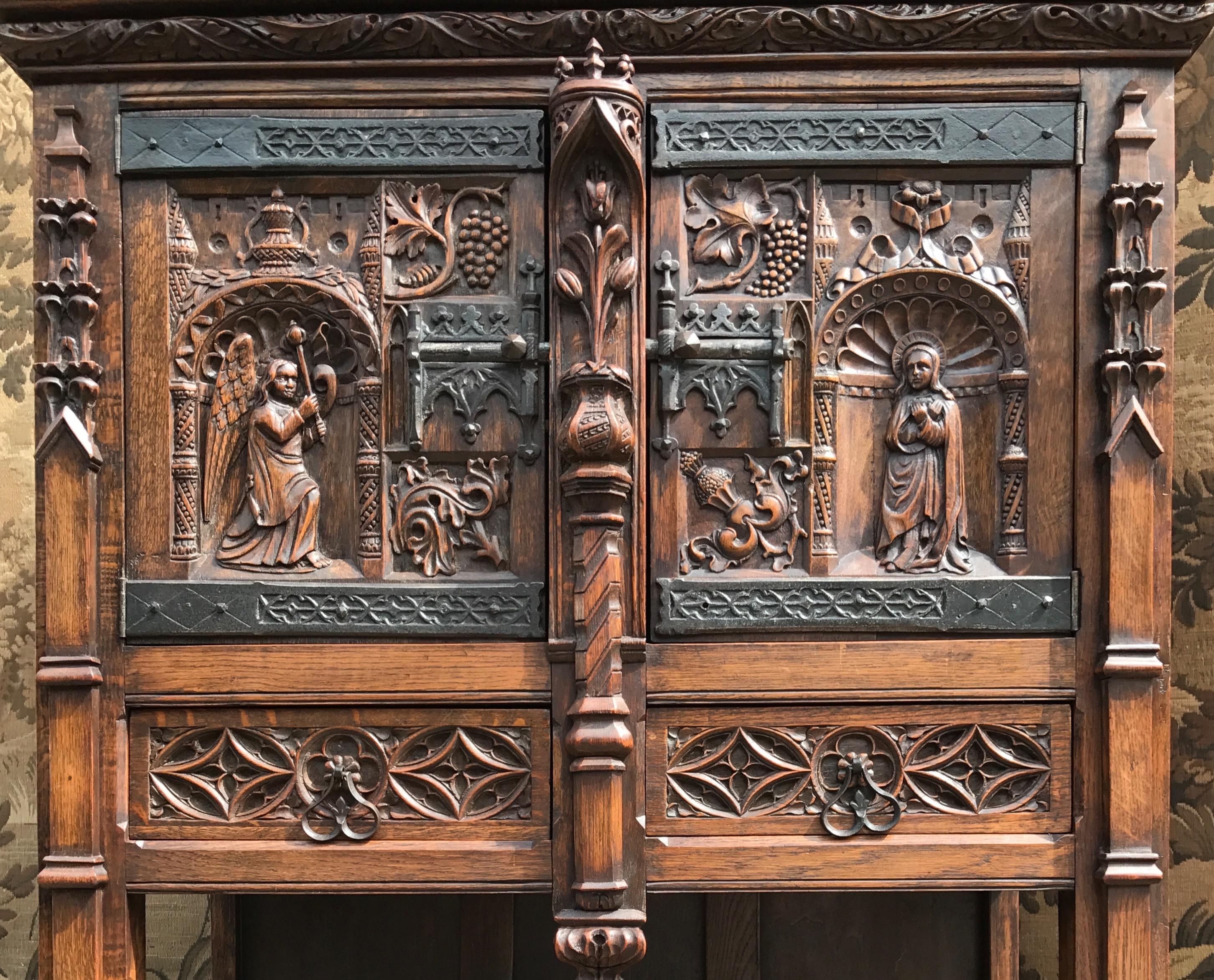 Marvelous and practical Gothic Revival, religious cabinet. 

You may never again get to see and purchase a Gothic Revival cabinet with more carved details than this wonderfully handcrafted example. This unique, Dutch Gothic cabinet in oak has an