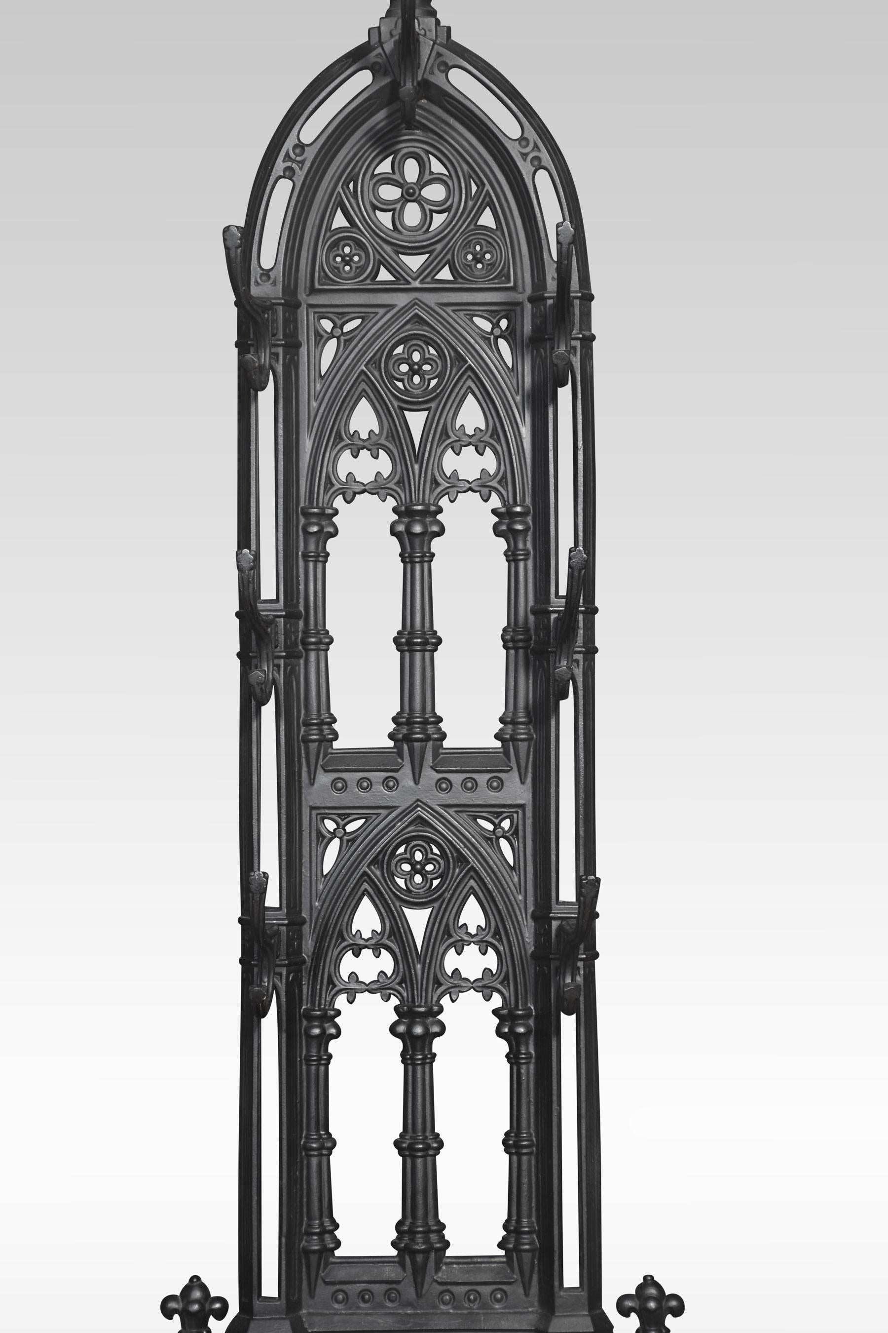 A Gothic Revival cast iron hall stand, having three tiers of decorated open arches with seven coat hooks and an umbrella stand below fitted with two removable drip pans to the shaped base.
Dimensions
Height 70.5 Inches
Width 30 Inches
Depth 12.5