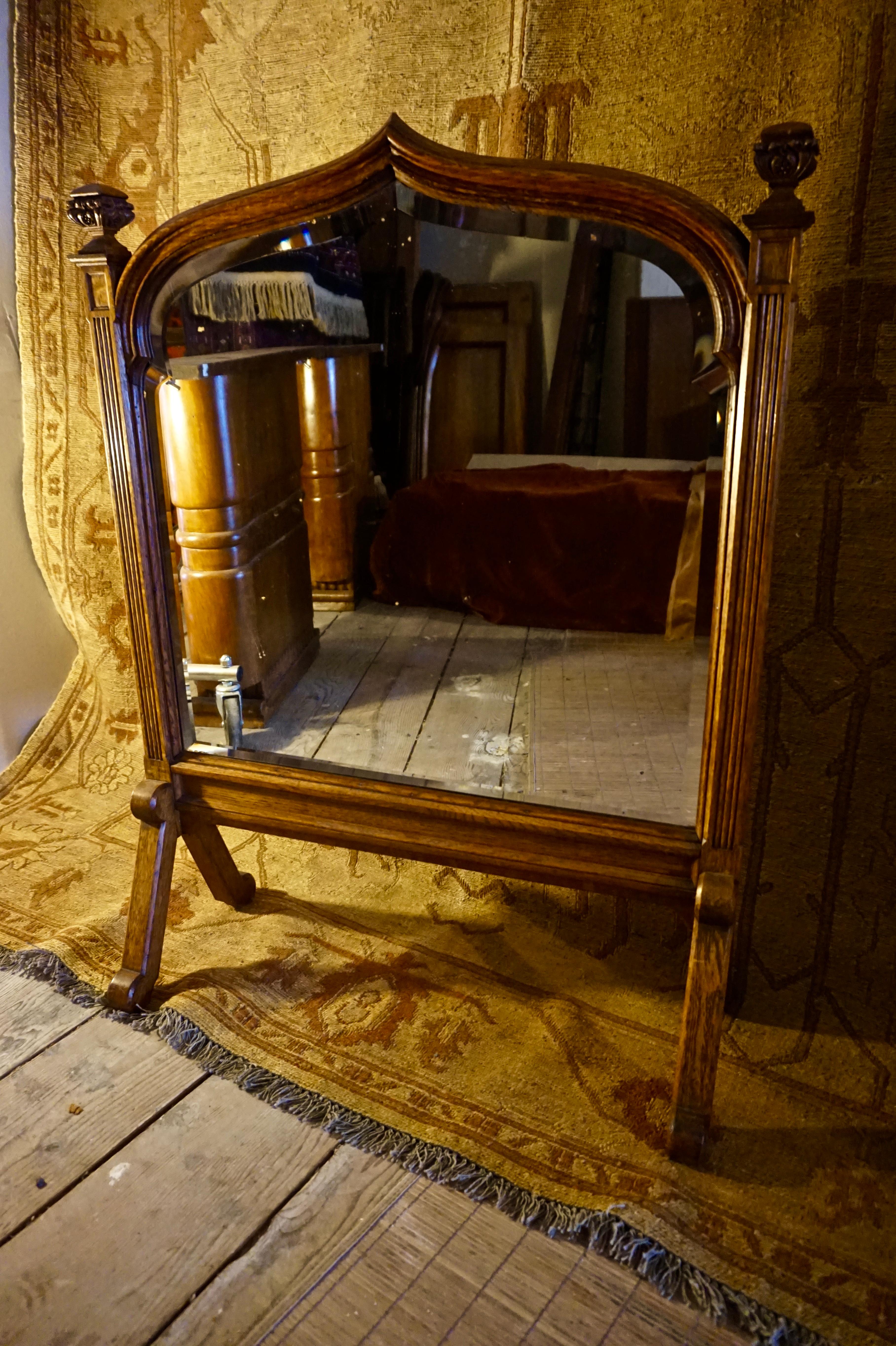 Rare Gothic mirror on legs with a unique shield shape and finials. Lead backed original bevel glass intact. Lovely patina and size with nice attention to subtle detailing,

circa 1860s.