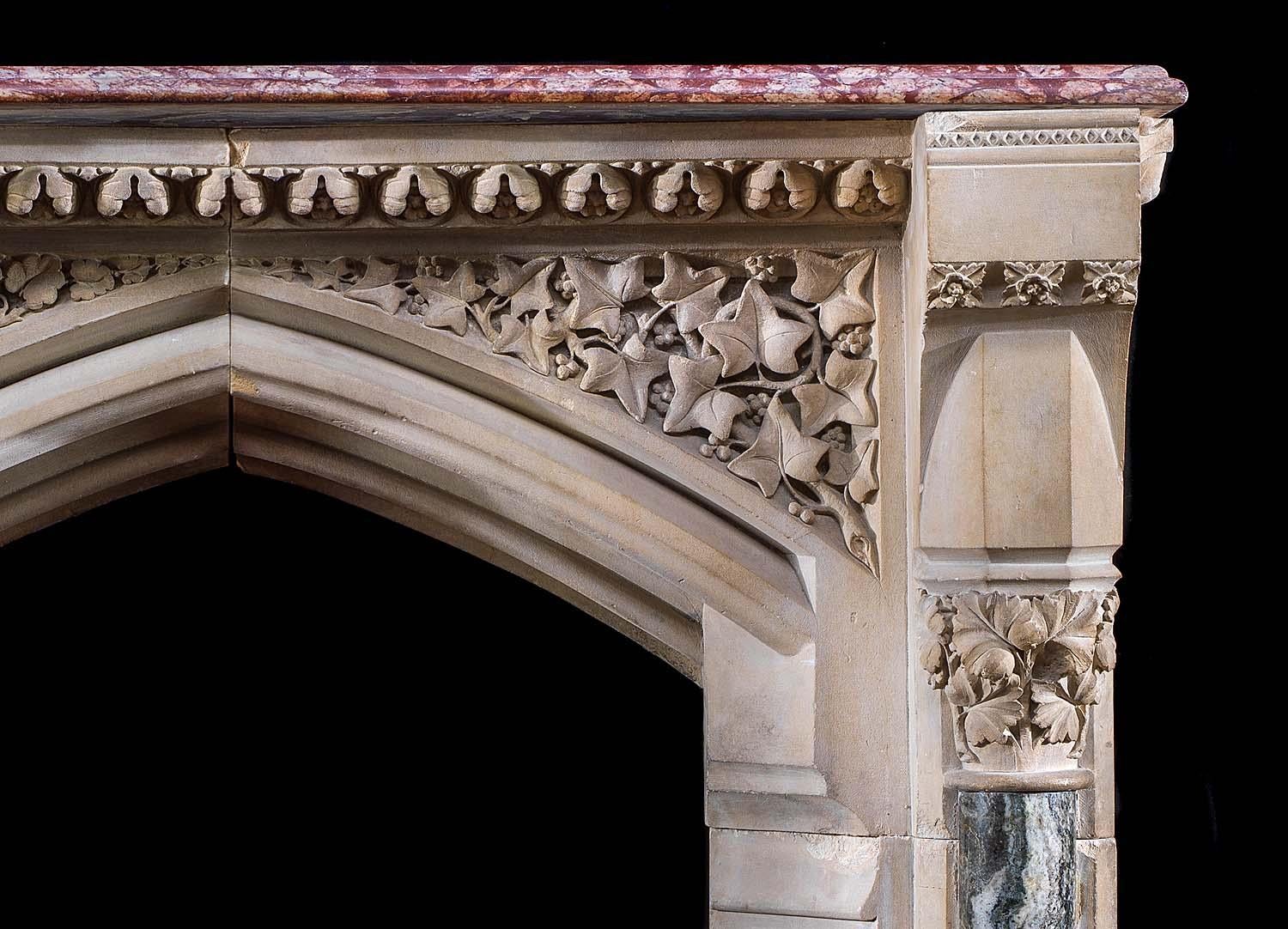 A rare Edward Pugin Gothic Revival fireplace, carved from Caen stone and marble. The fine rose red breccia marble shelf and carved under shelf are flanked by projecting faceted end blocks. Beneath the shelf are a pair of high relief spandrels,