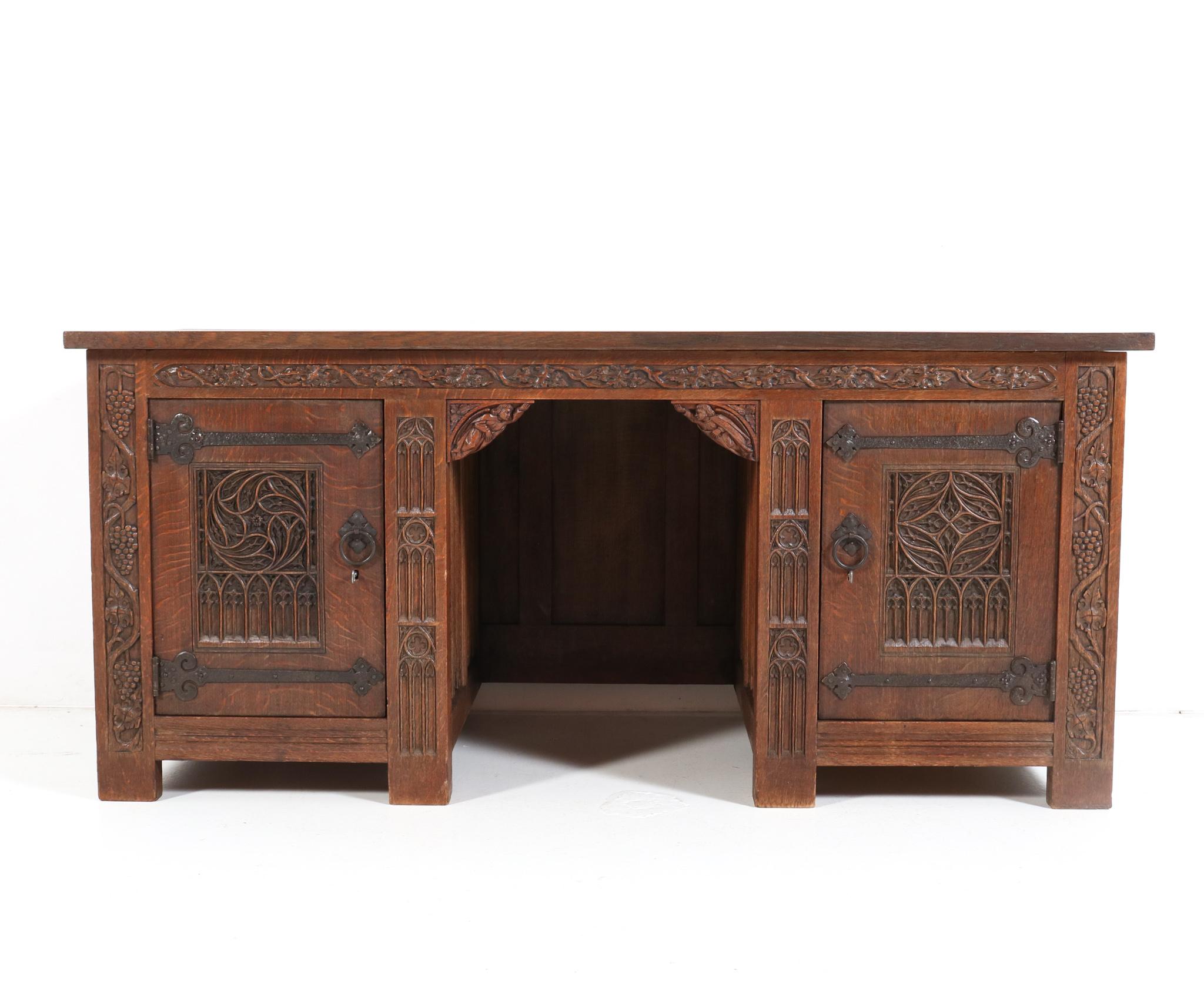 Magnificent and ultra rare  Gothic Revival pedestal desk. 
Striking Dutch design from the 1900s
The craftsmanship of this impressive piece of furniture is outstanding!
Executed in solid oak with original hand-carved Gothic cathedral window-like