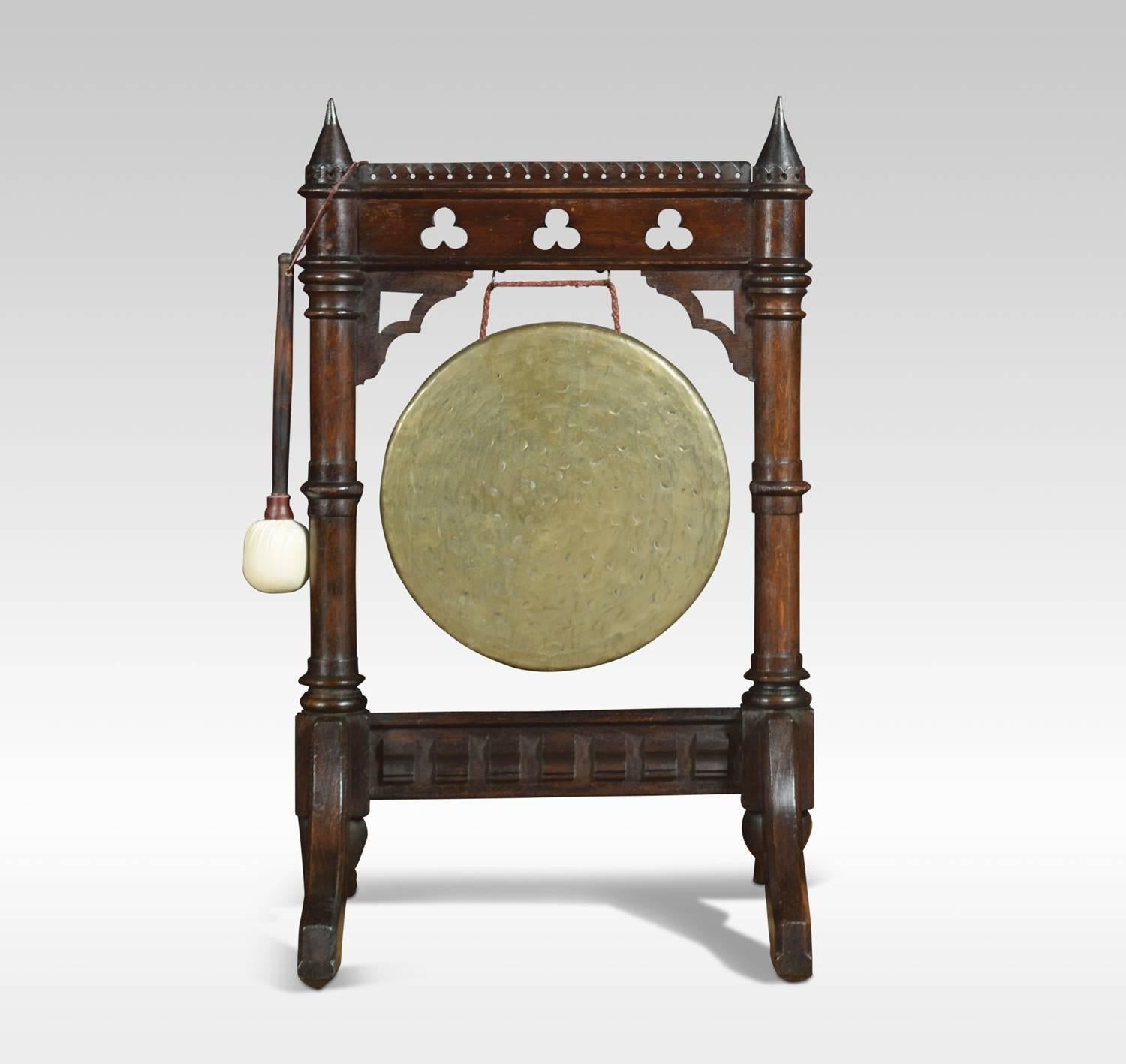 Late Victorian oak framed dinner gong and beater, the cone shaped finials above pierced carved Gothic frame with suspended brass gong to centre raised up on shaped feet
Dimensions:
Height 34 inches
Width 20.5 inches
Depth 19 inches
Diameter of