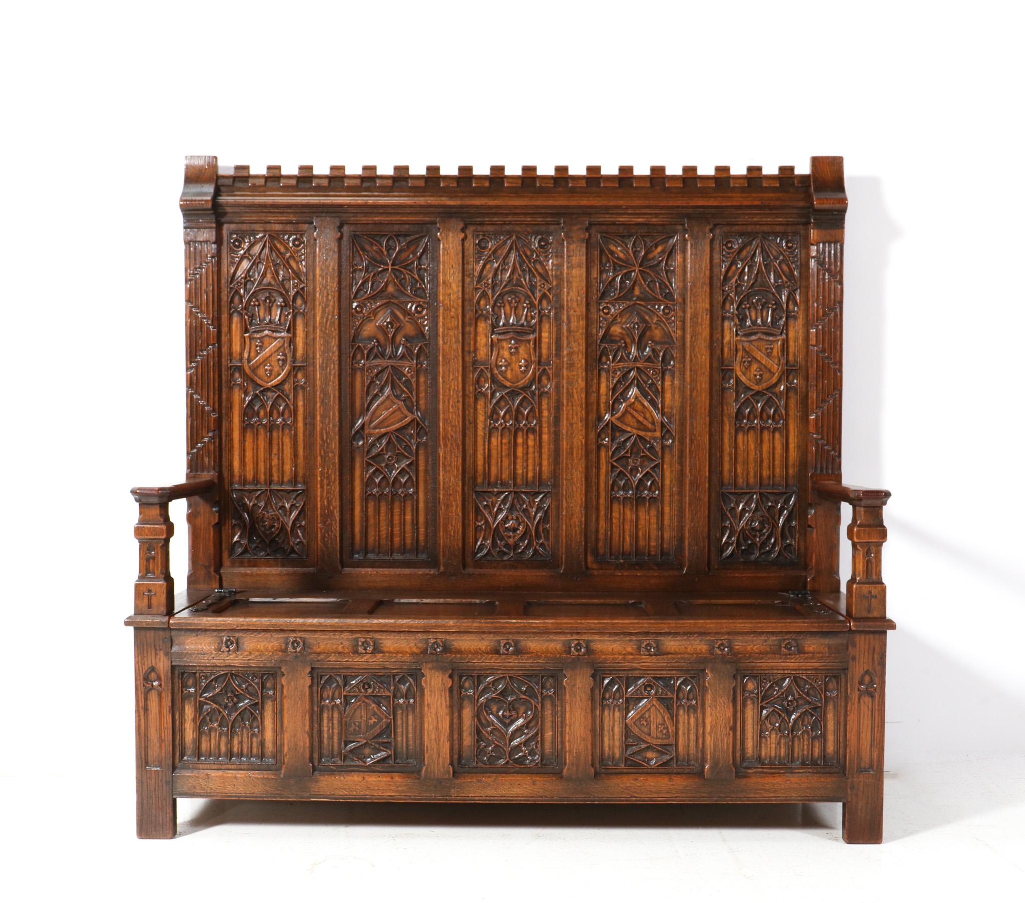Magnificent and ultra rare Gothic Revival high back hall bench.
Striking Dutch design from the 1900s.
Solid oak frame with original hand-carved elements in the back and the sides!
Underneath the seat with the two original wrought iron hinges, you