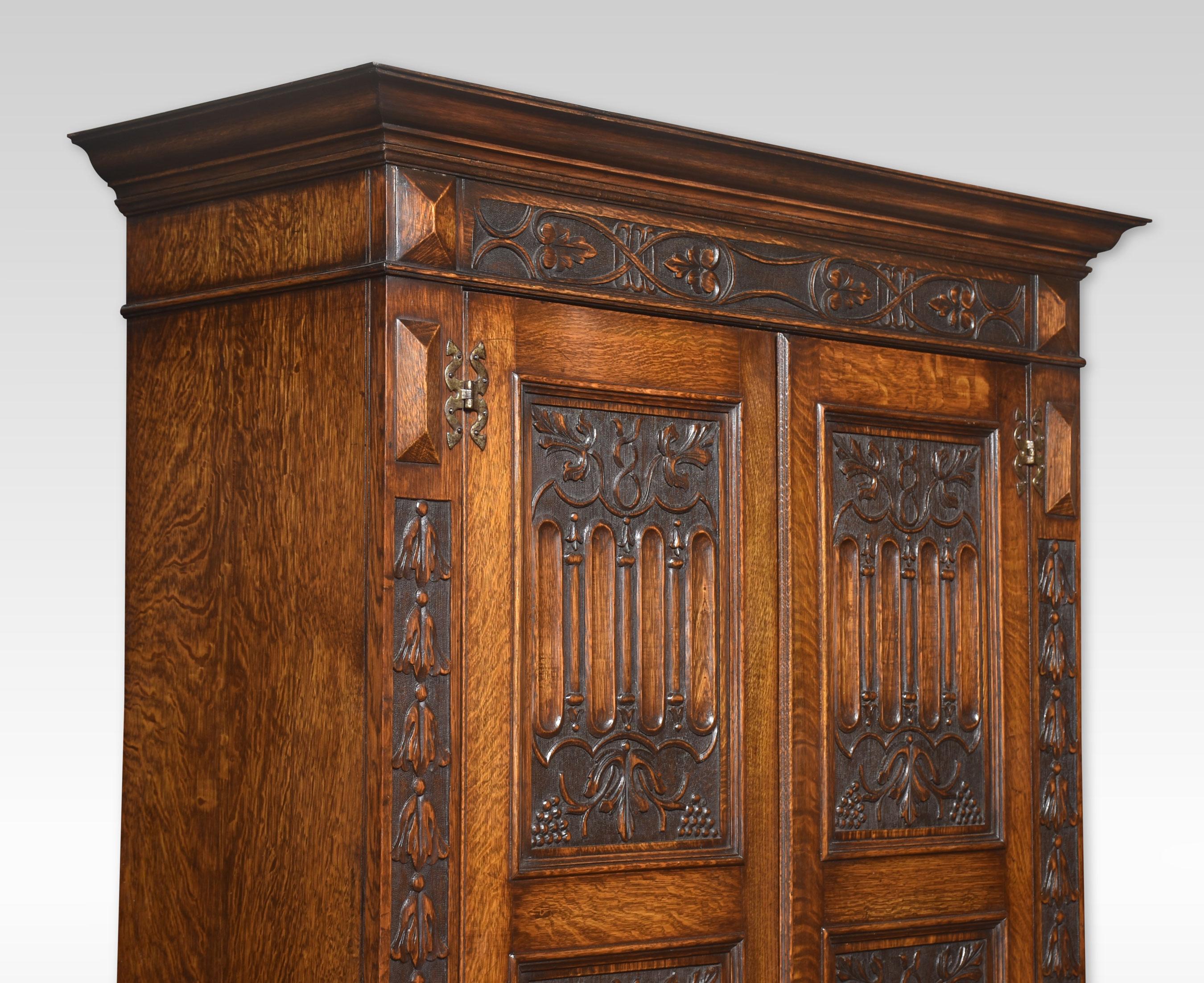 Gothic revival oak wardrobe the projecting cornice above two large panelled doors having Gothic carving throughout, the two panelled doors opening to reveal a large storage area and hanging rail. Raised up on a plinth base.
Dimensions
Height 76.5