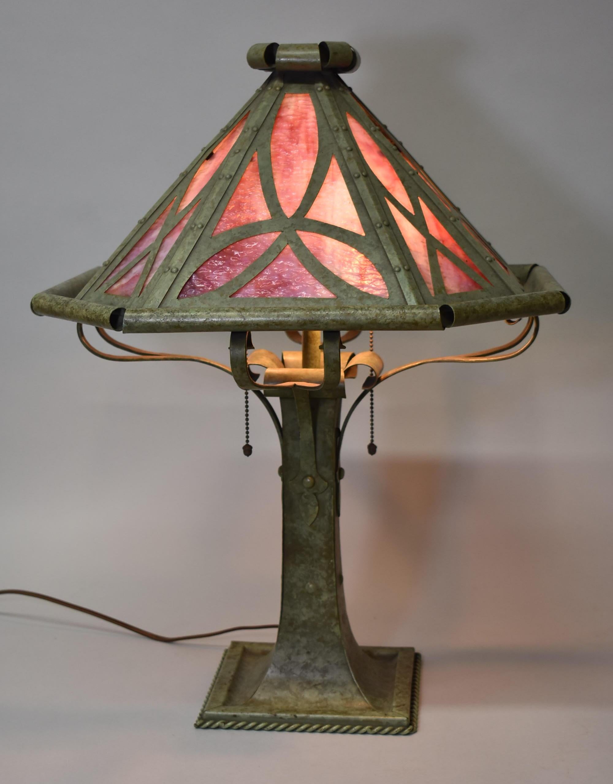 Gothic Revival slag glass lamp by Bradley & Hubbard. Fabulous patina. Two Hubbell sockets with acorn pull chains. Eight cranberry and opal panels. Shade has riveted construction. Rewired with new rayon cord.