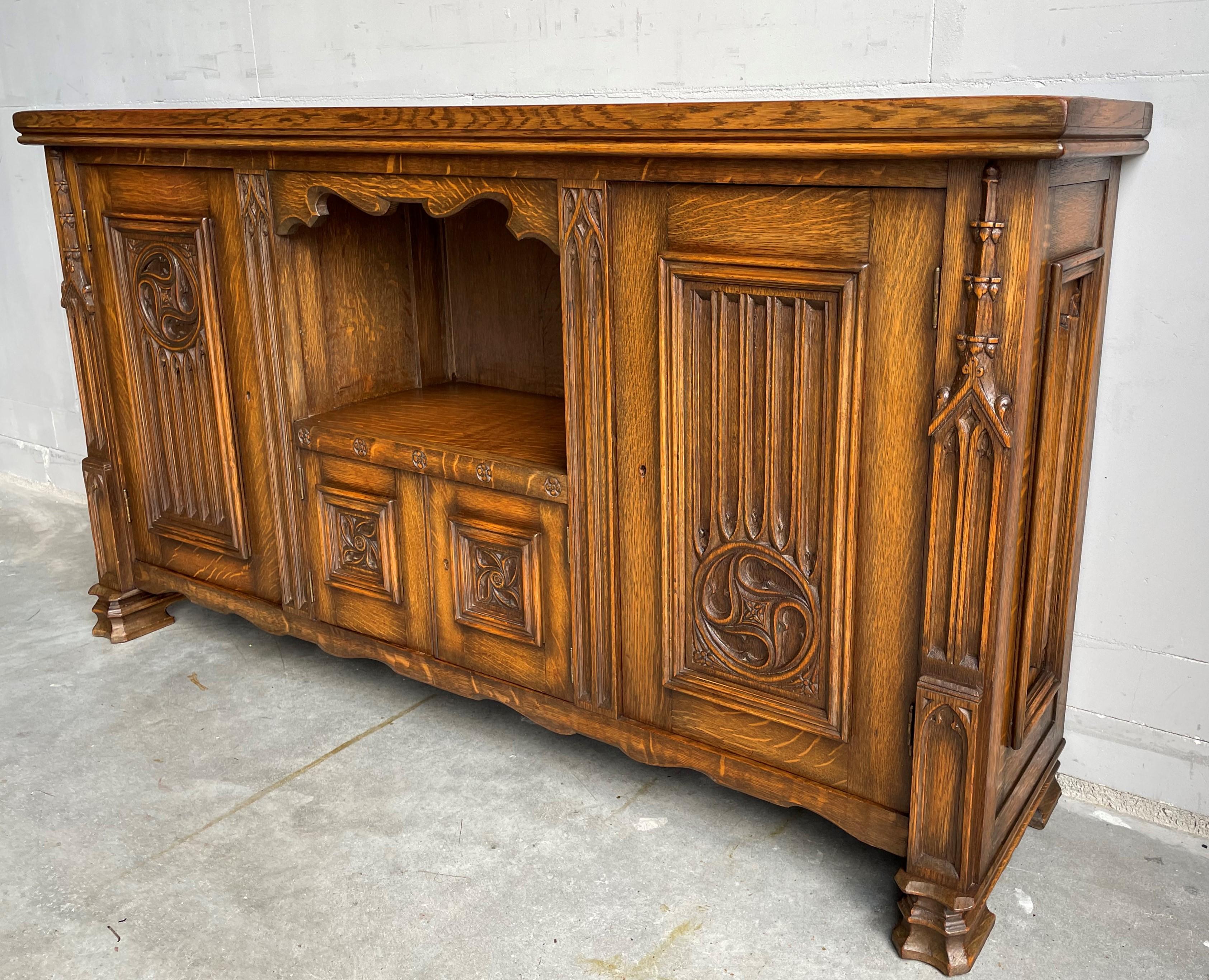 Beautiful and practical size, hand carved Gothic cabinet.

This antique Gothic Revival cabinet can be placed tight on your wall and thanks to its wide and undeep design this medieval style beauty can be placed almost anywhere whilst hardly taking up