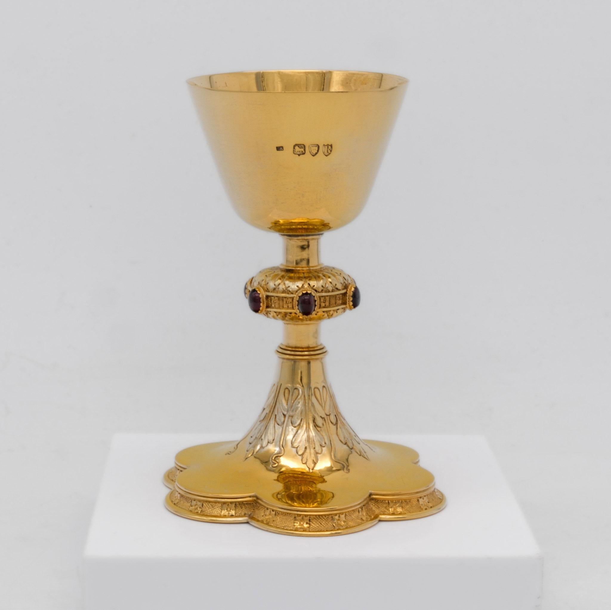 Precioso cáliz de plata dorada de estilo gótico victoriano engastado con piedras. Por Carl Christopher Krall (1844-1923) Hallmarked for London 1892.

Este fino cáliz se eleva sobre una base hexafoil festoneada con un borde en forma de pañal y