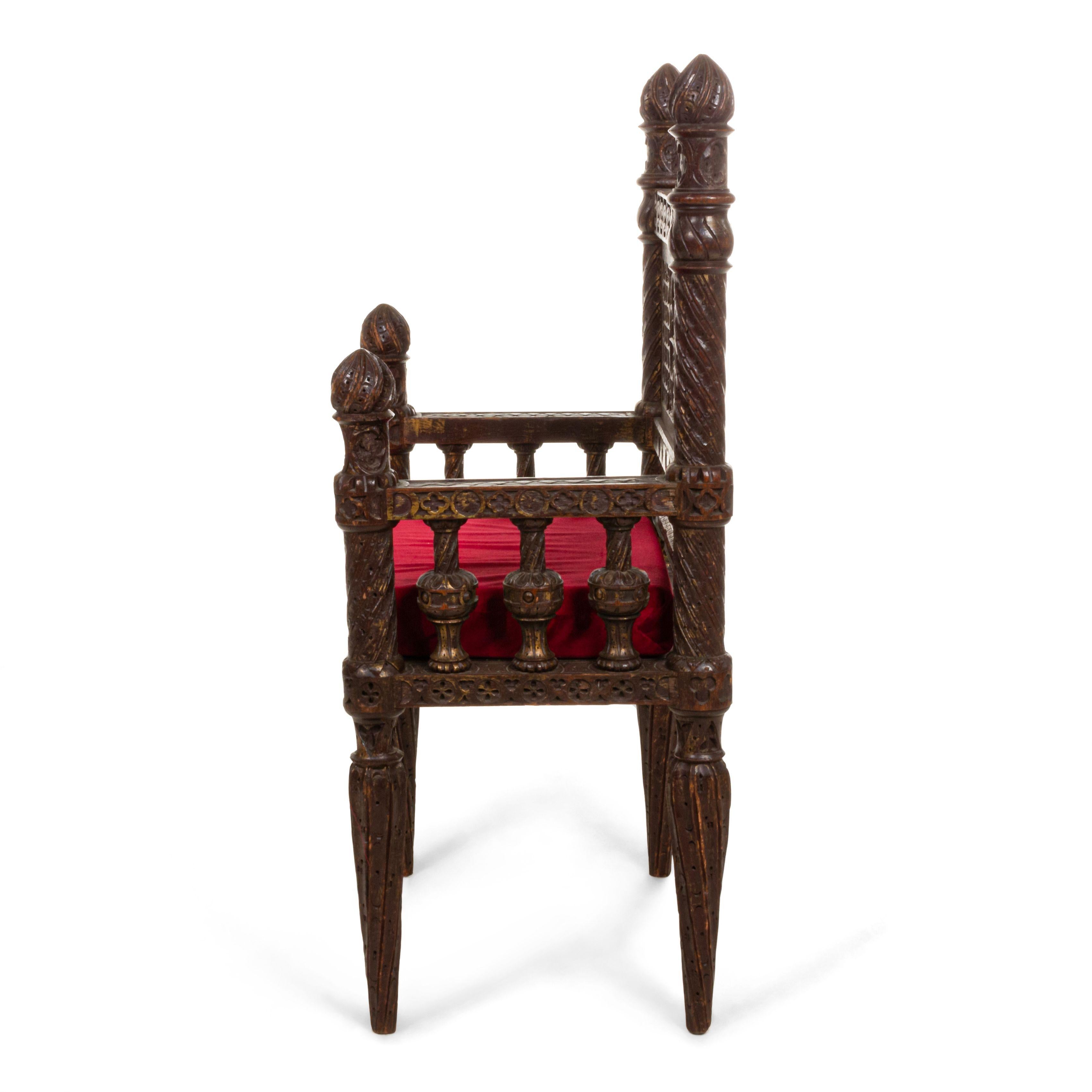 English Victorian Gothic Revival style carved burgundy painted & gold trim small (throne) arm chair with carved center medallion and finials on back.
 