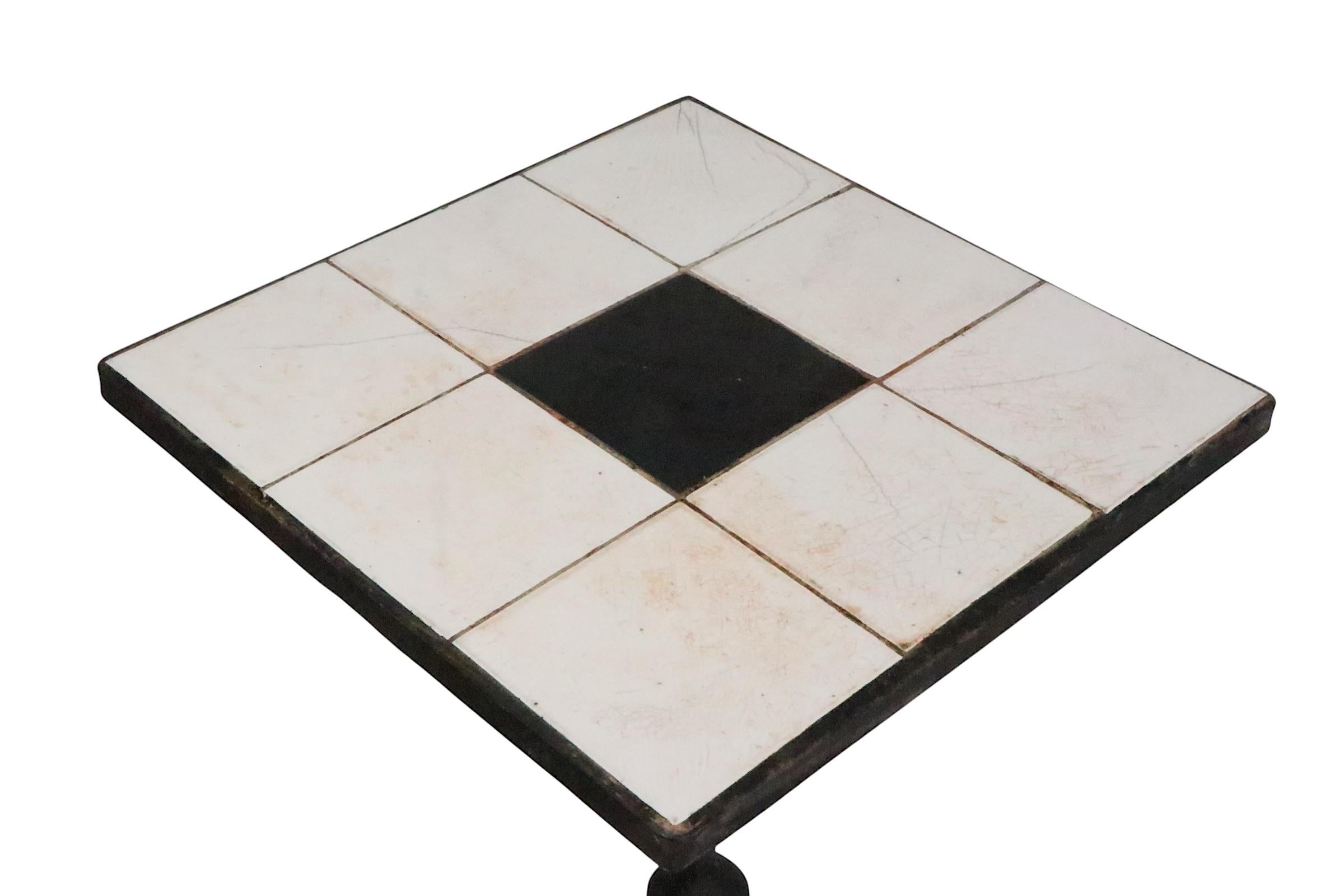 Superbe cache-pot en fer forgé et tuiles, piédestal, porte-boisson, avec un métal bien exécuté.  base de travail, avec un  graphique géométrique  dessus en carreaux noirs et blancs. Le support est structurellement sain et robuste, le plateau en