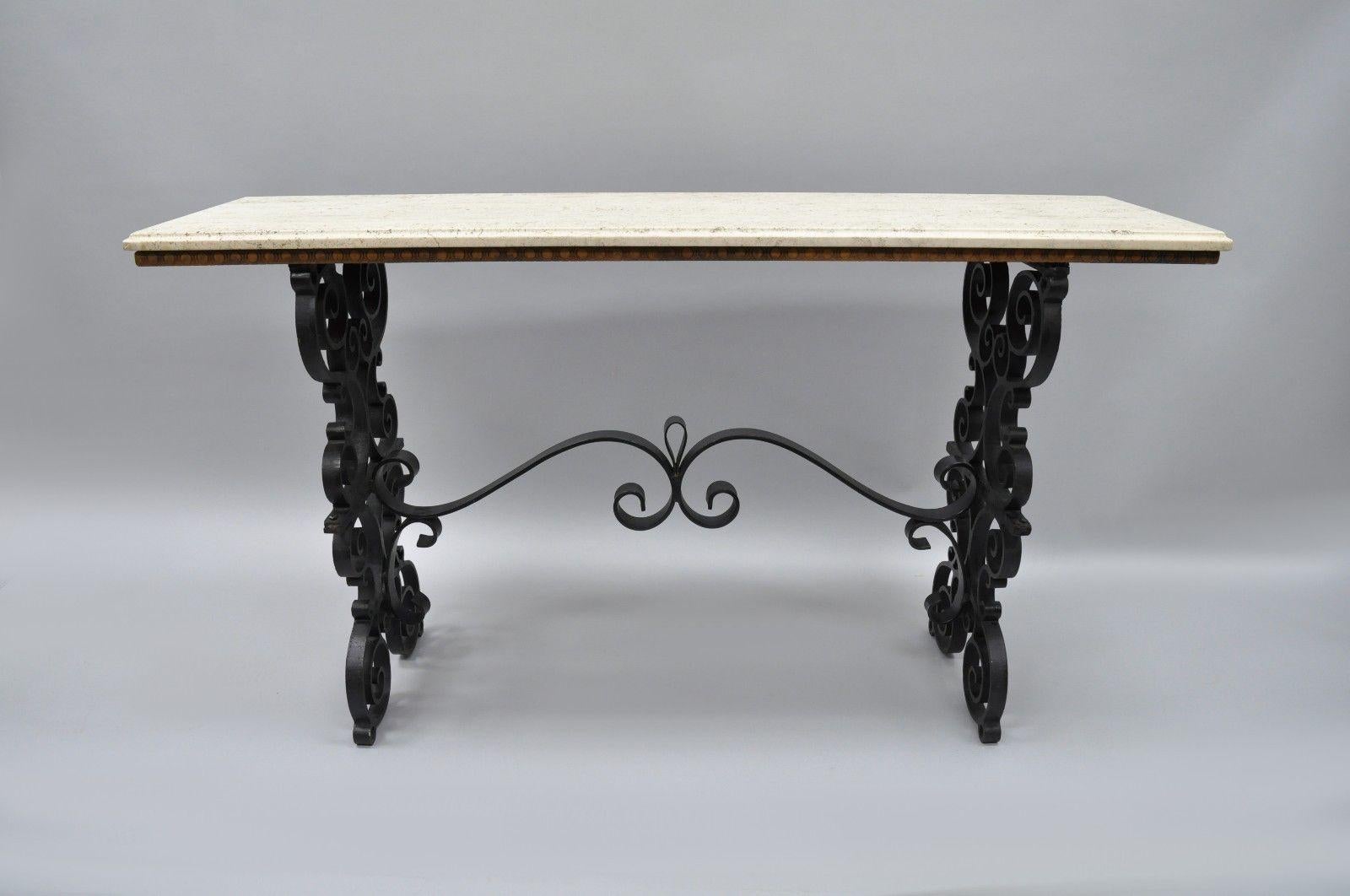 Gothic scrolling wrought iron console table. Item features travertine stone top, fancy scrolling wrought iron base, ornate stretcher base, wooden support to stone top, great Gothic form and quality, circa early to mid-20th century. Measurements: 30