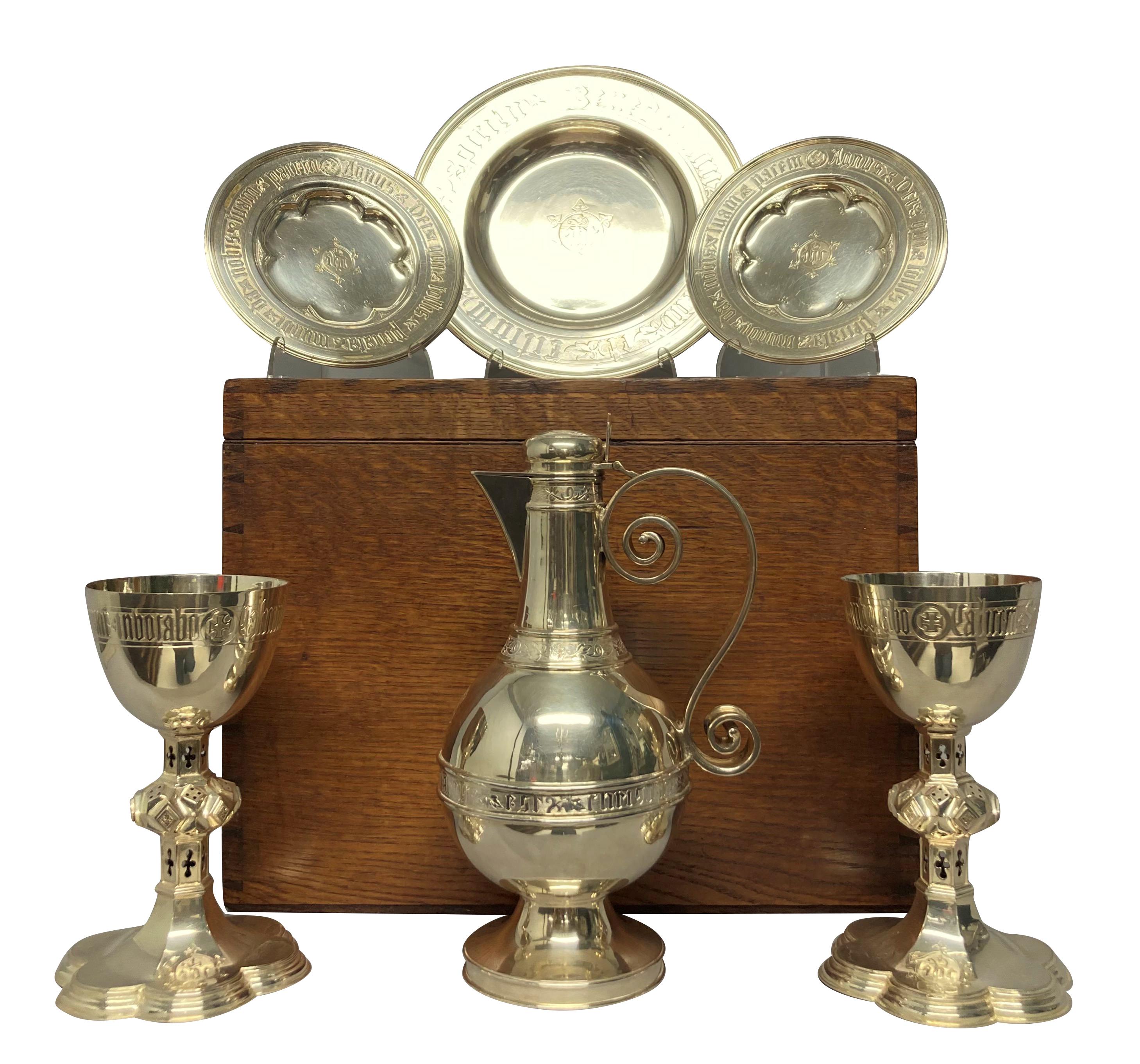 An English Gothic silver plated communion set with their original box by Henry Wilkinson & Sons of Sheffield. Comprising two chalices, two patens, a ewer and a plate. Each ornately engraved and stamped. The chalices are also numbered. The oak box,
