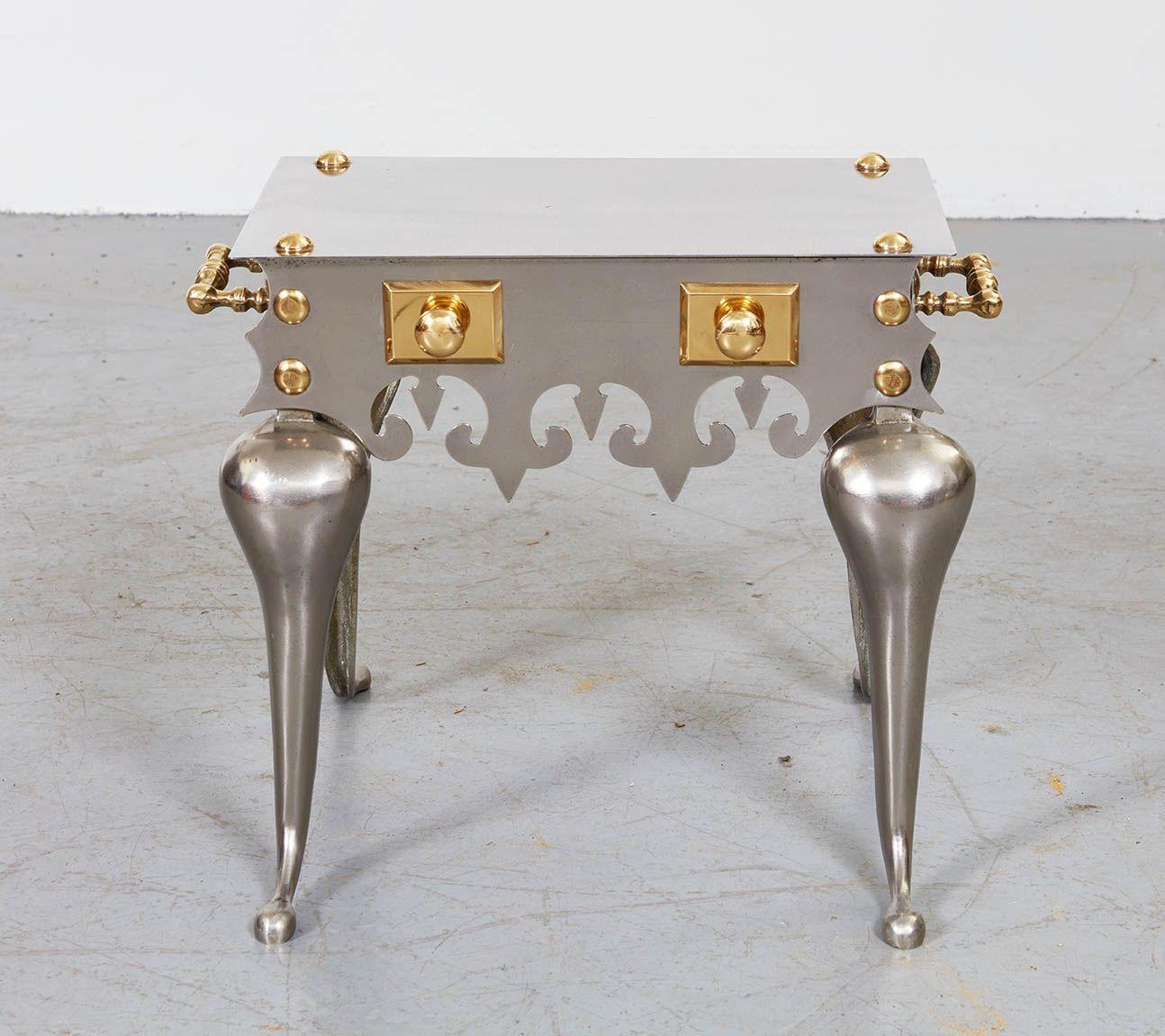 Heavy Gilded-Age drinks table or trivet made of polished steel in the gothic manner with flamboyant cabriole legs and brushed steel top featuring fleur-de-lys cut apron and elaborate brass detailing including turned handles, rivets and decorative