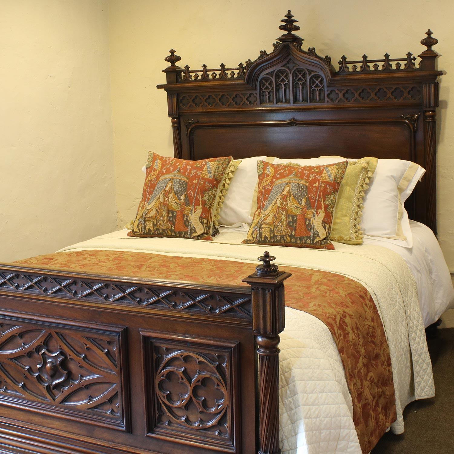 This fabulous Gothic inspired bed has superb carving in the head and foot including linen folds, fleur-de-lys and quatrefoils, typical of the style. The architectural form is emphasised by the column posts, the cut-out quatrefoils in foot board and