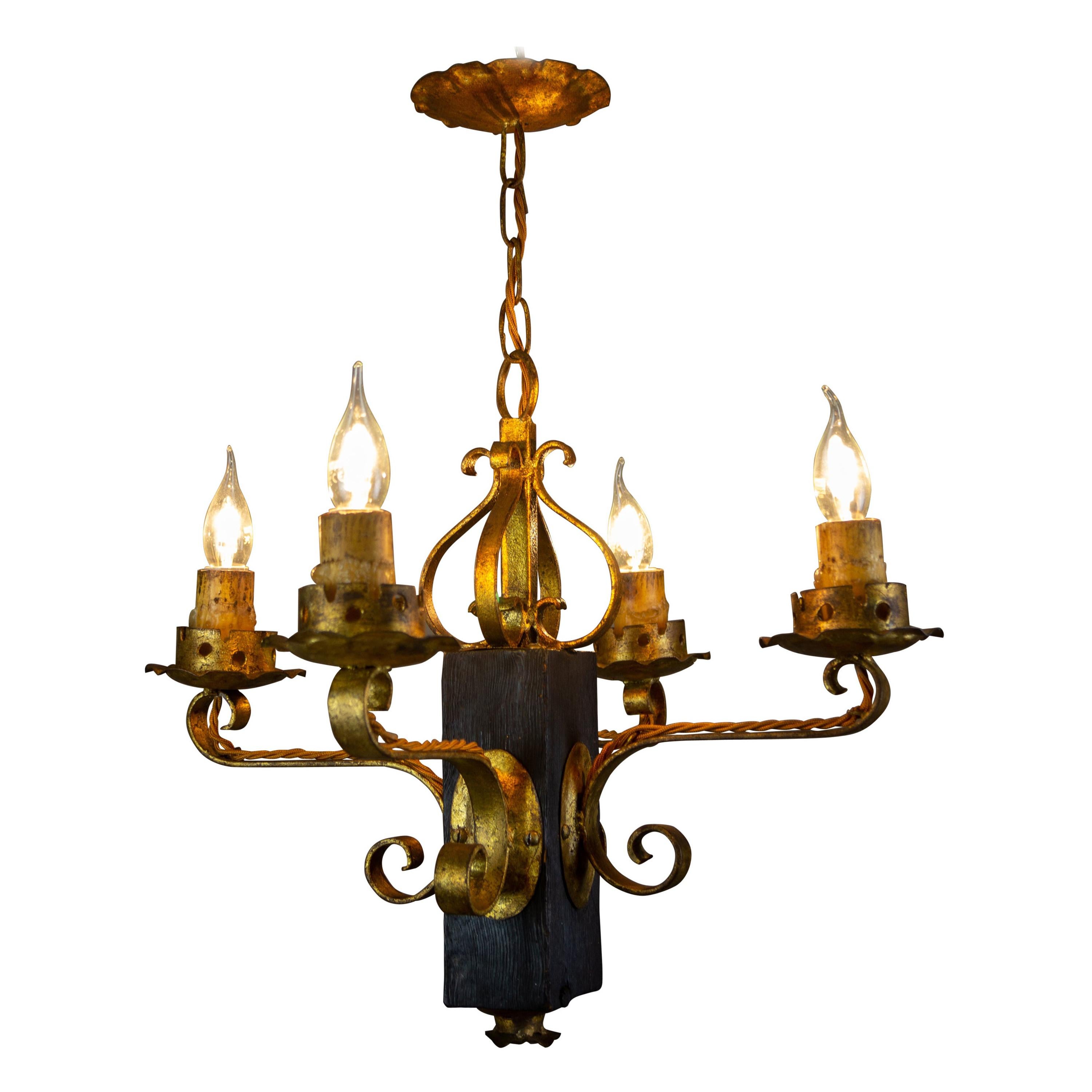 Gothic Style Gilt Wrought Iron and Black Wood Four-Light Chandelier